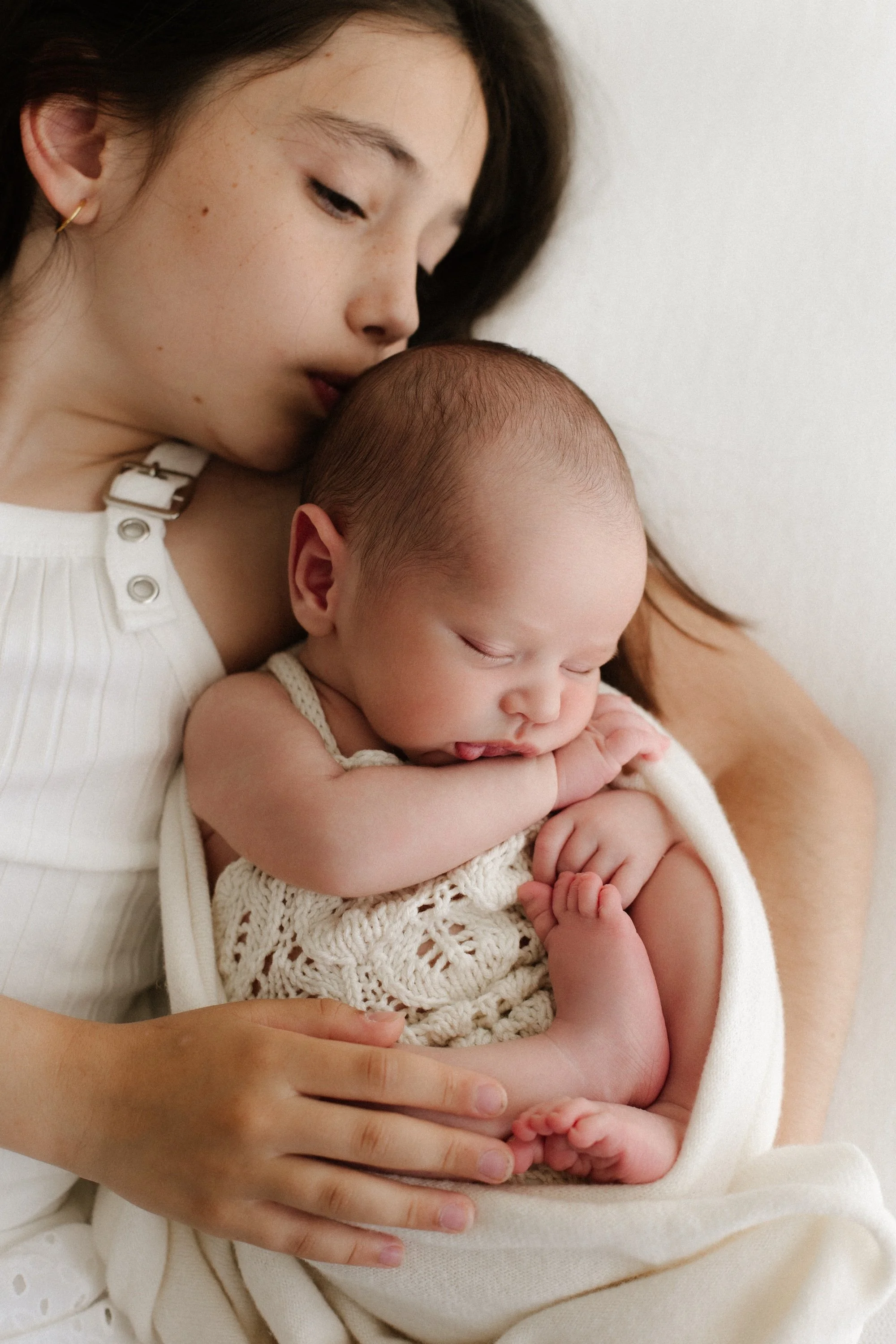 Baby newborn during photoshoot in a timeless white setting