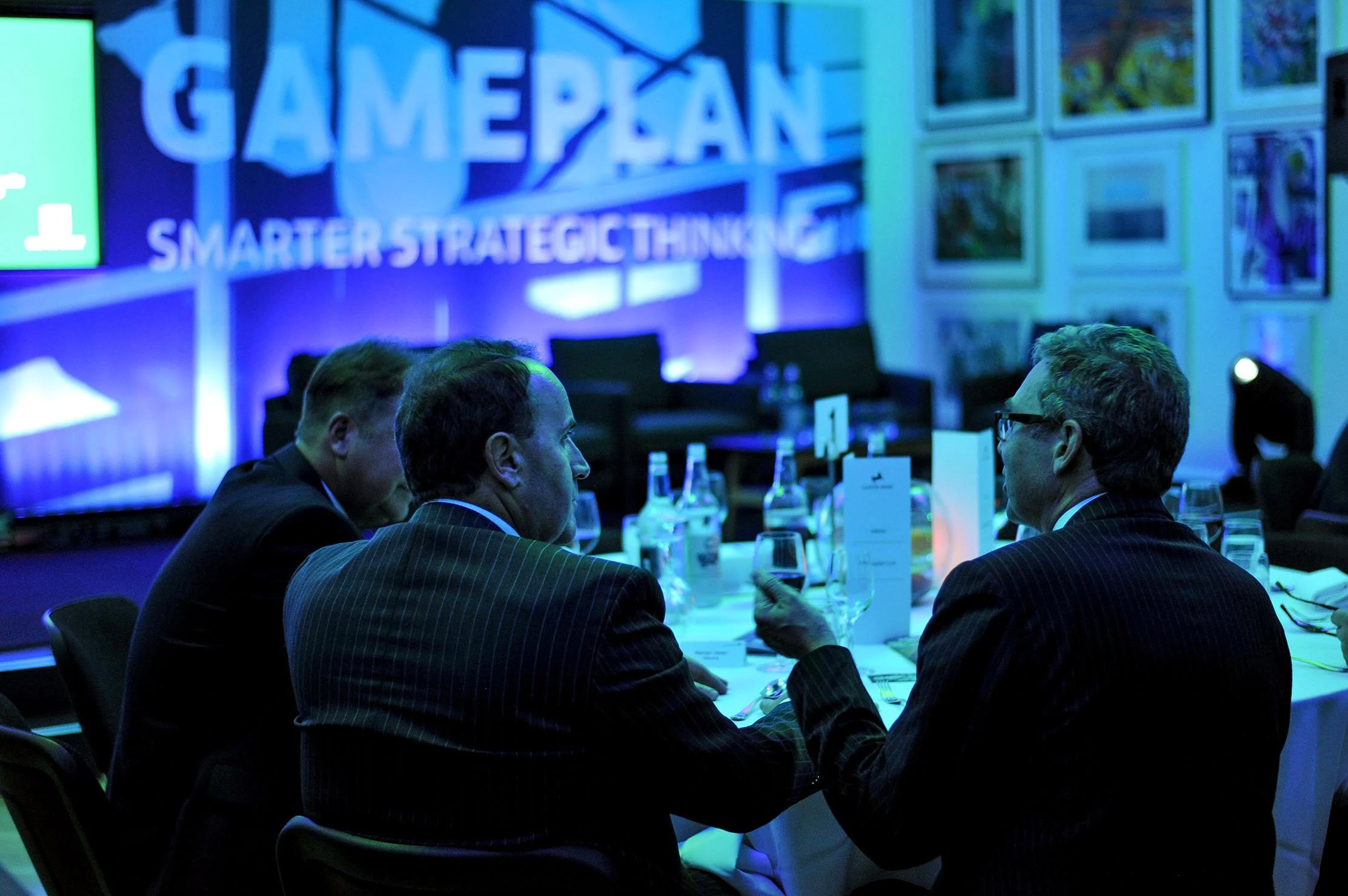 Men in suits hold discussions during a business event