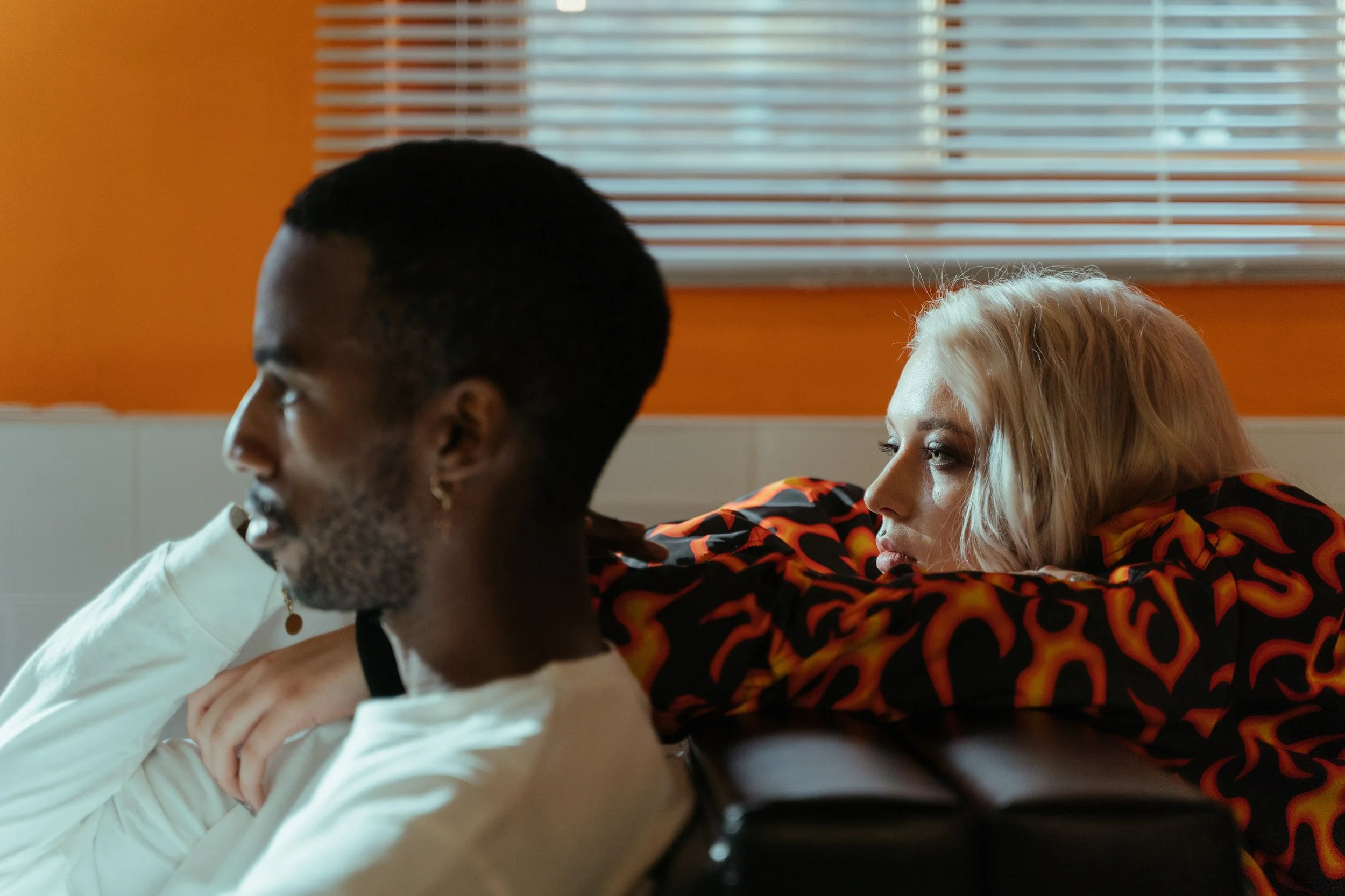 Couple sitting apart on a couch, illustrating quiet quitting a relationship and growing emotional distance between partners.