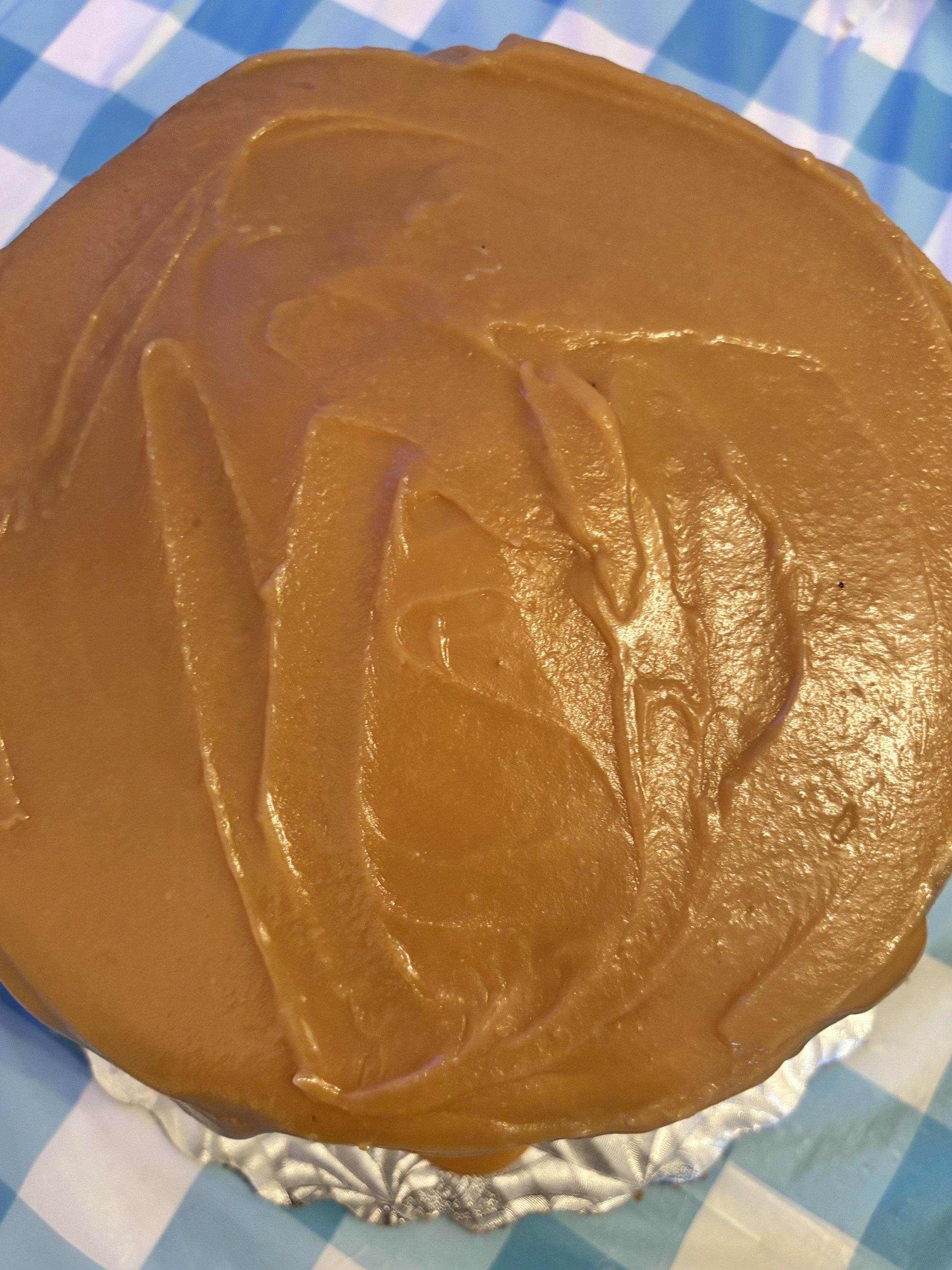 Three-layer caramel cake featuring a glossy caramel glaze and a soft, fluffy texture