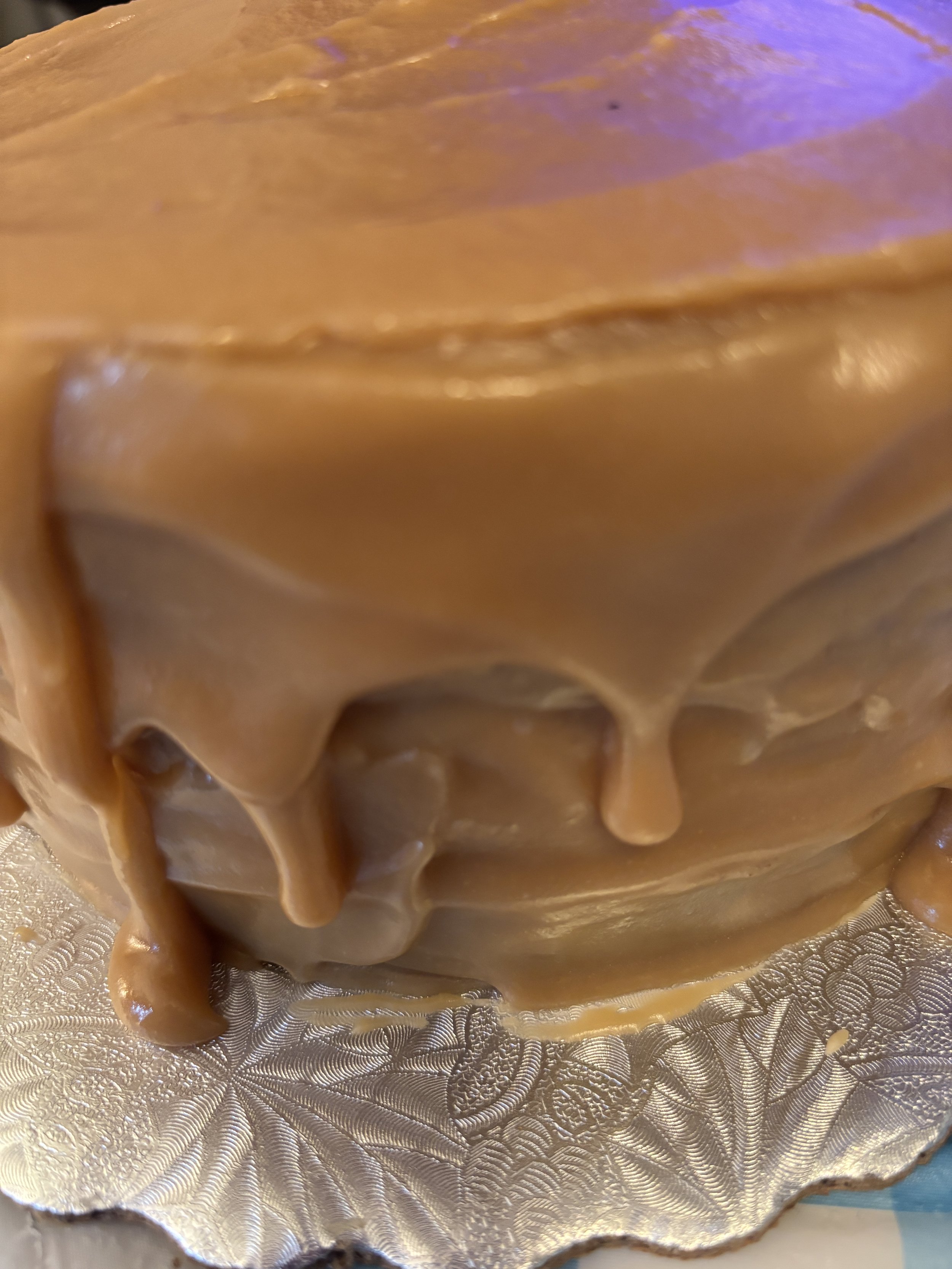 Homemade three-layer caramel cake with golden caramel icing, perfect for special occasions or everyday indulgence.