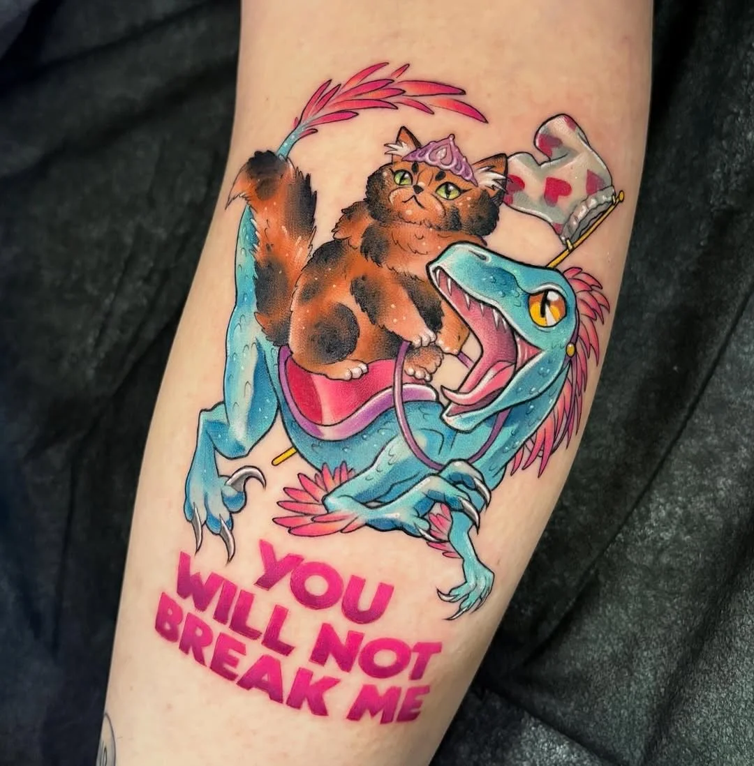 Cat &amp; raptor character tattoo by resident artist @rogueheart.tattoo
&bull;
Ok, Sara has totally convinced me to check out Dungeon Crawler Carl, so it&rsquo;s next on my book list, especially after tattooing these two cuties! 🏰 Have you read DCC?