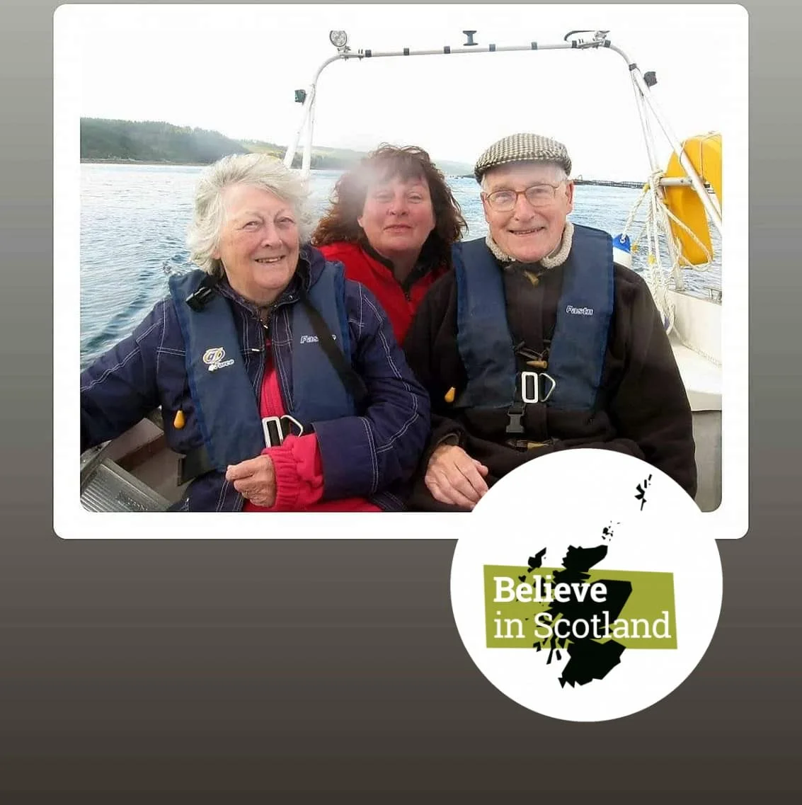 Three people wearing life jackets sit together on a boat. They appear to be enjoying a day out on the water. A "Believe in Scotland" logo is overlaid on the image.
