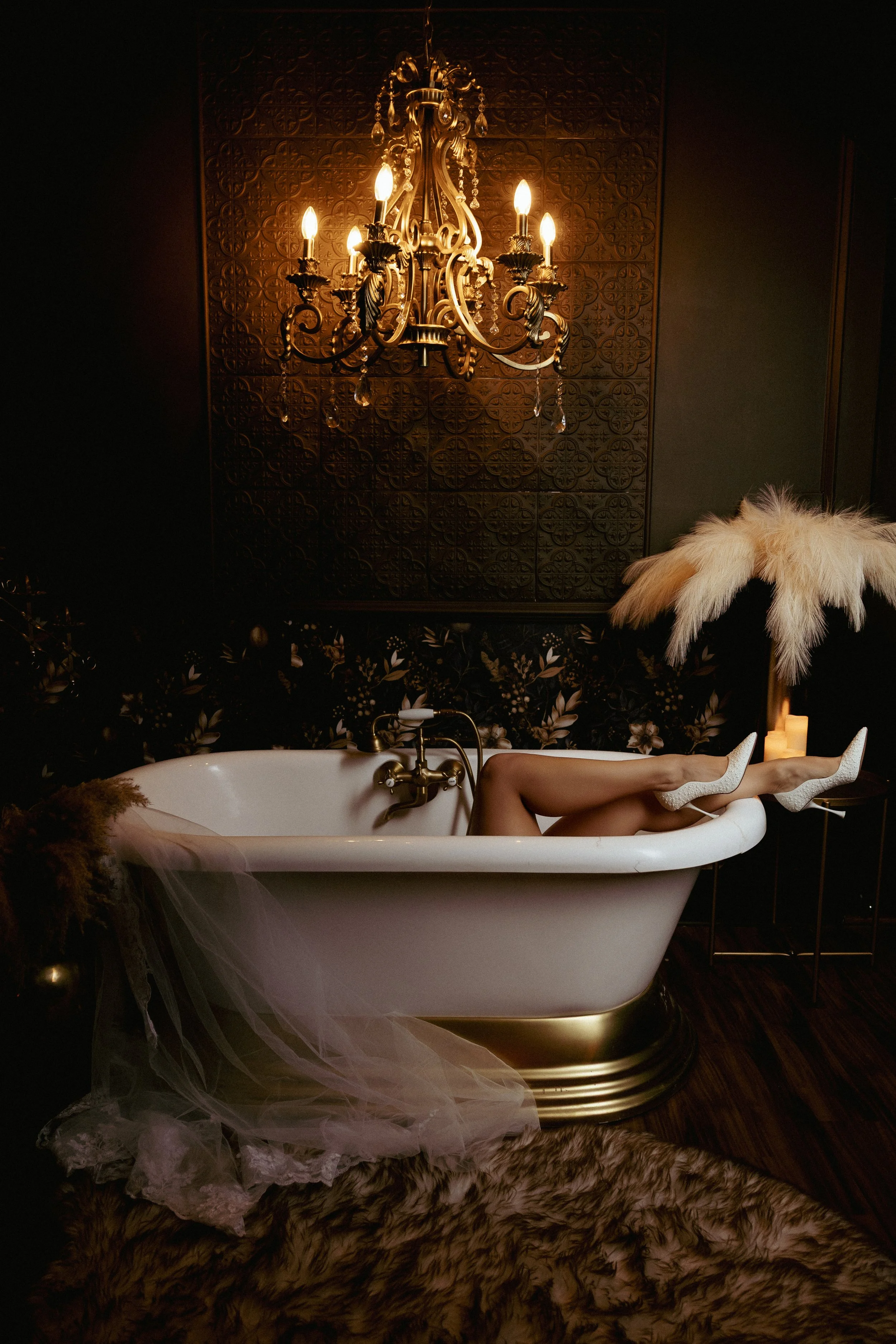 Bridal boudoir photo of a bride’s legs and feet in wedding heels playfully posed over the edge of a bathtub.