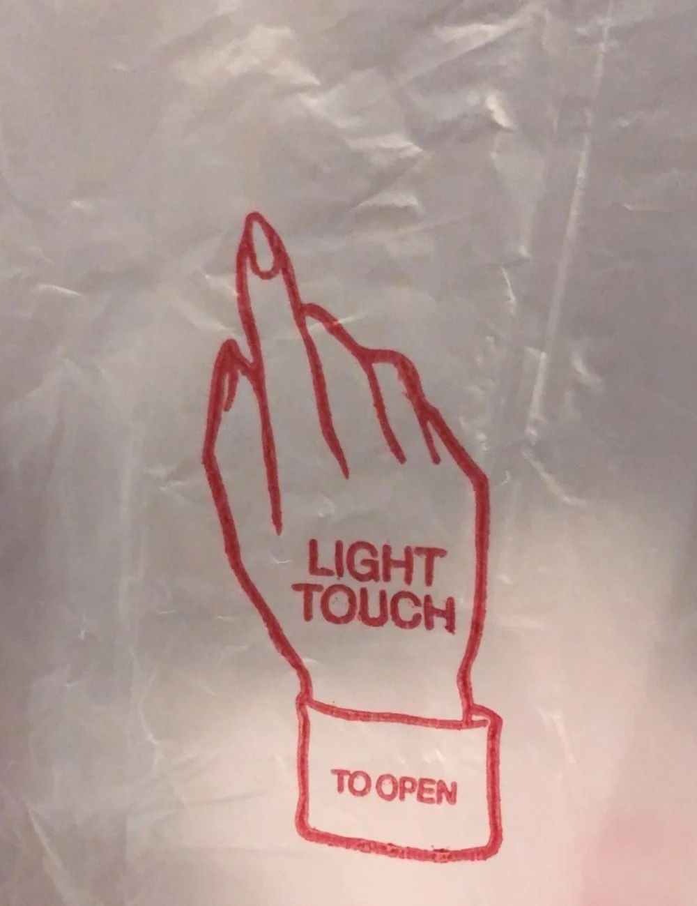 Graphic of a hand with the index finger extended, labeled "Light Touch To Open" on plastic bag.