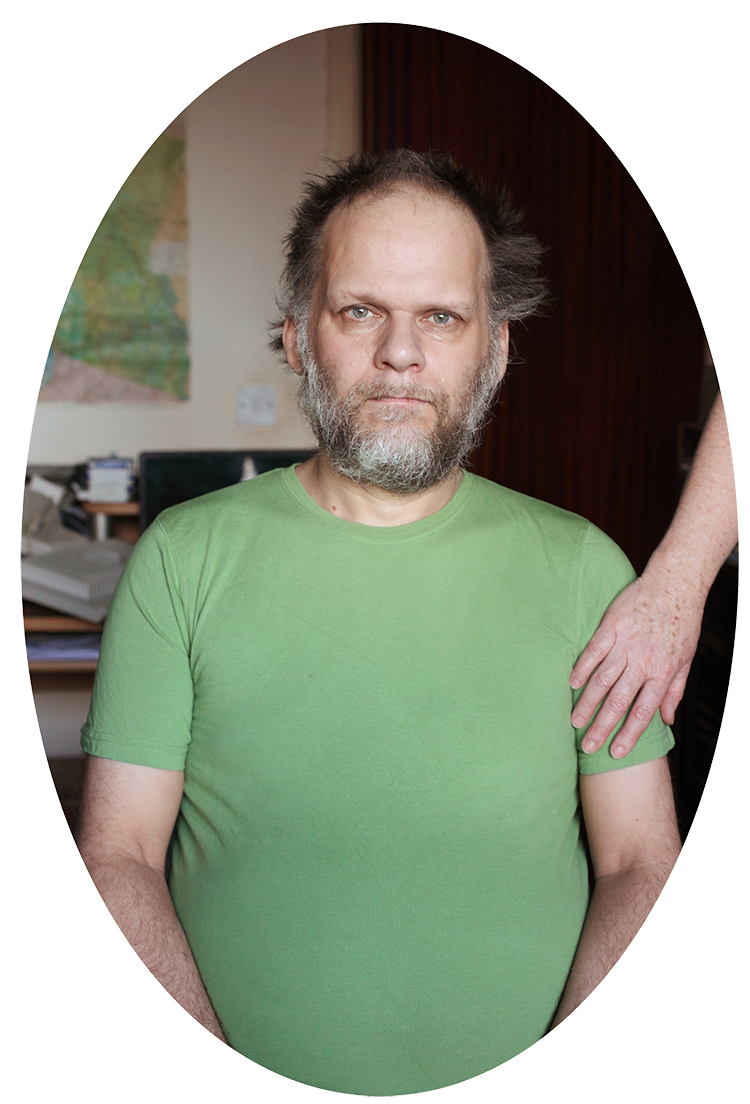 Man wearing green shirt with hand rested on shoulder