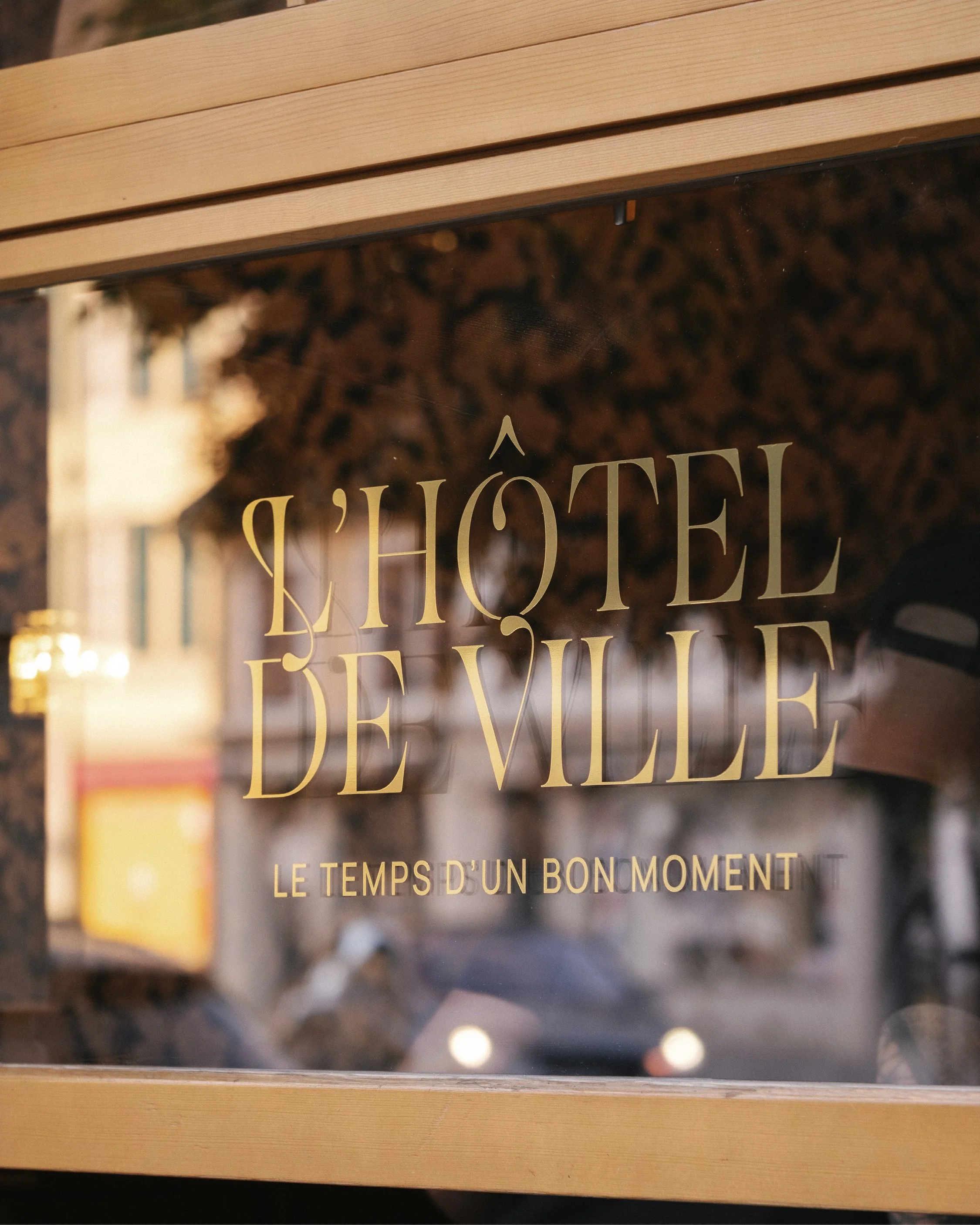 Le nouveau logo du restaurant de l'Hôtel de Ville de Bulle marque sa vitrine avec un adhésif or, pensé par Paradoxe Studio en charge du graphisme du restaurant