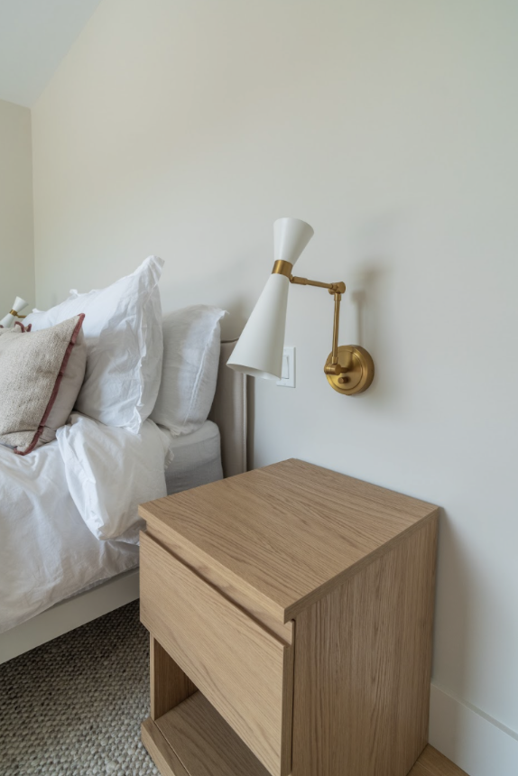 Wall sconces create a reading light source and also work together with the furniture design to balance all of the room contents.