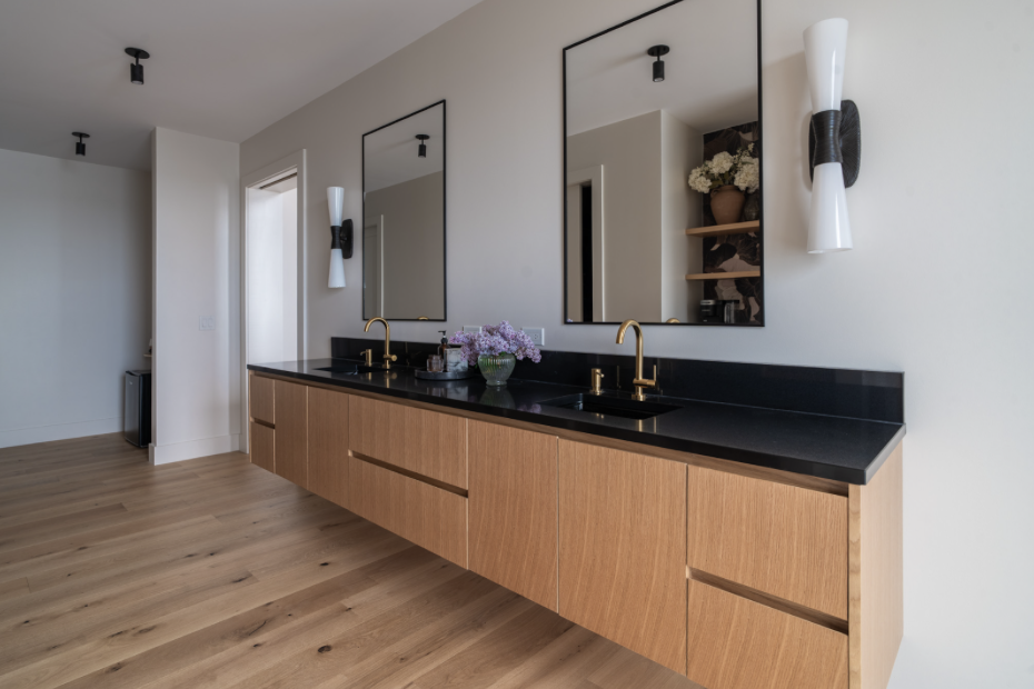 Sconces flanking double sinks provide another lighting layer. At the same time the style of the sconces match the home interior so that a design theme is brought to life through lighting.