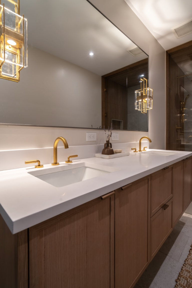 In this design, we used sconces on the actual mirror wall to further reflect ambiance back into the bathroom space. The glow against the mirror is a reflective effect that provides a feeling of luxury and hotel inspired design. 