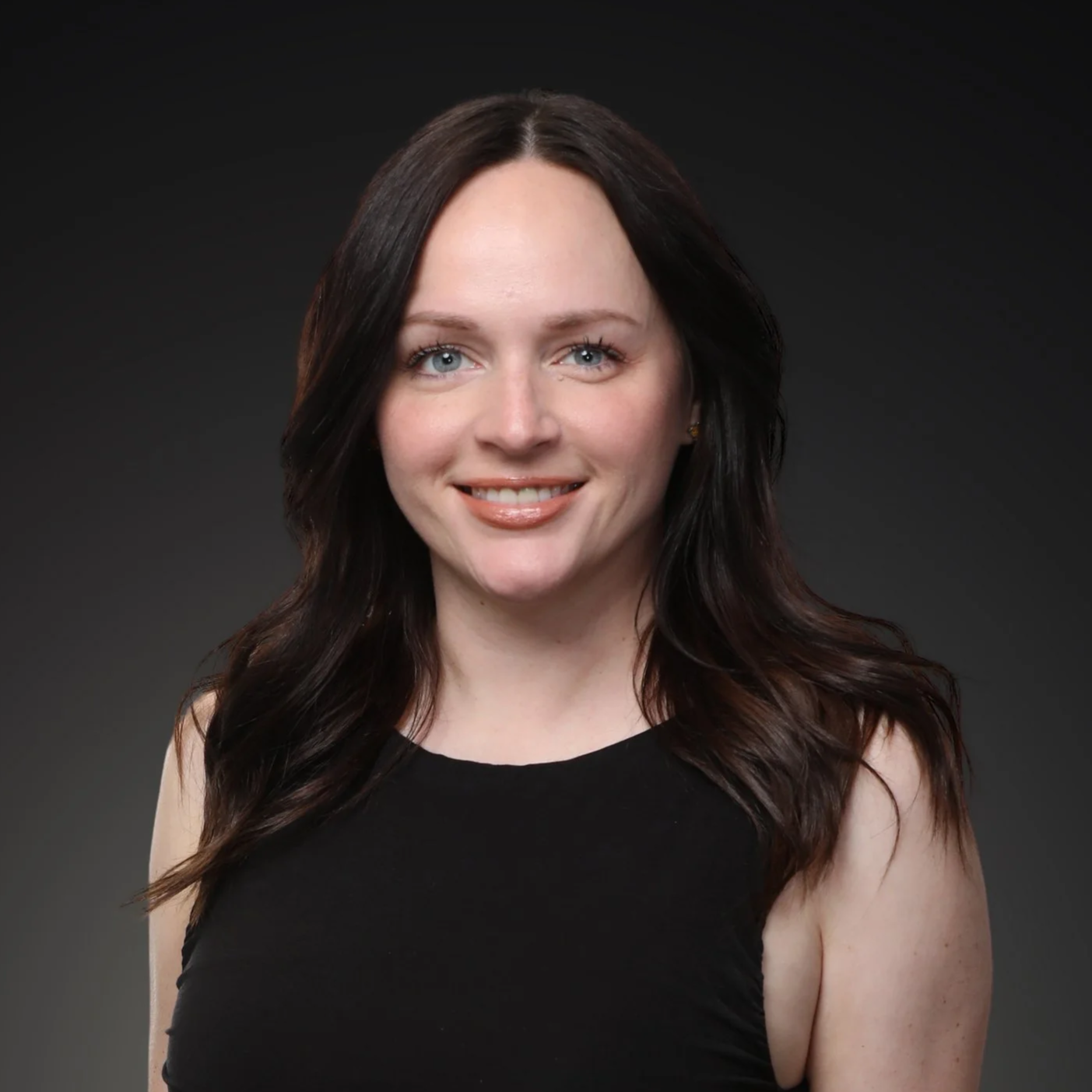 Portrait of a woman with shoulder-length dark brown hair, blue eyes, light makeup I Scott Brown Properties I Denton, TX 