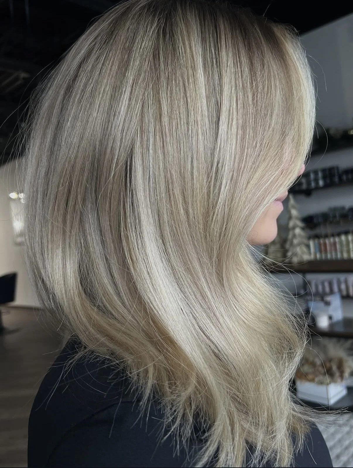 Side view of blonde, shoulder-length, layered hair in a salon setting.