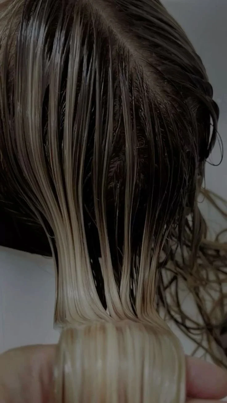 Close-up of wet, blonde and light brown hair strands hanging down