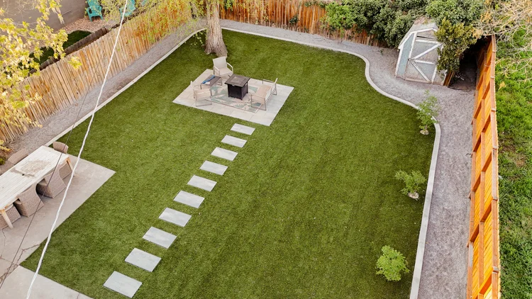 Stepping-stone path across a turf backyard