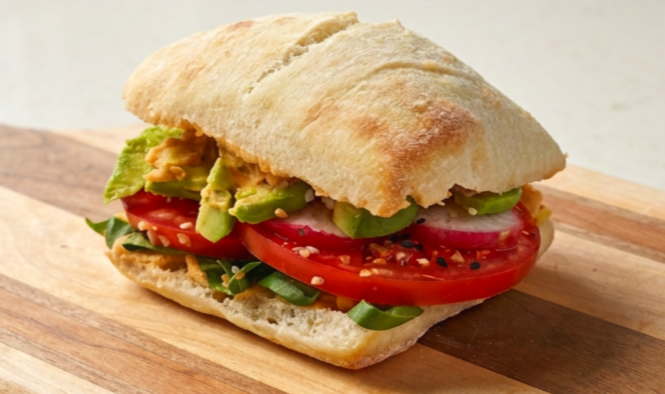 a smoky and creamy avocado sandwich on a cutting board
