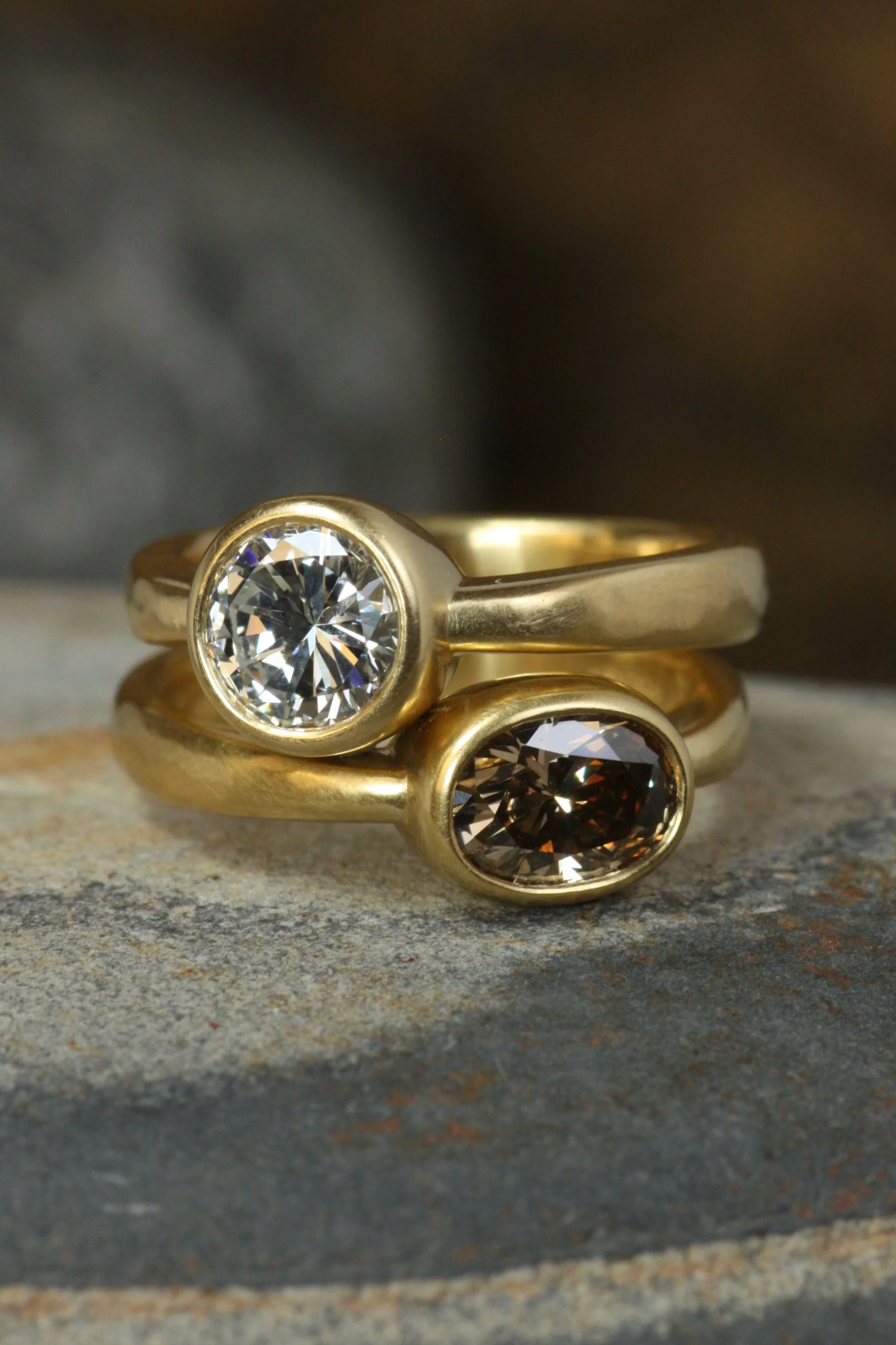 two diamond bezel engagement rings stacked on top of each other