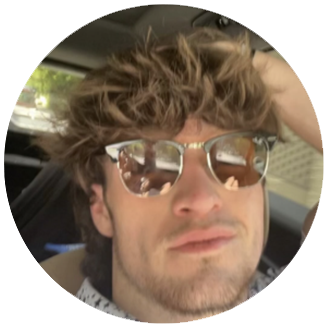 Photo of Kaden- White man with short brown hair and a neutral facial expression in the car with sunglasses on.