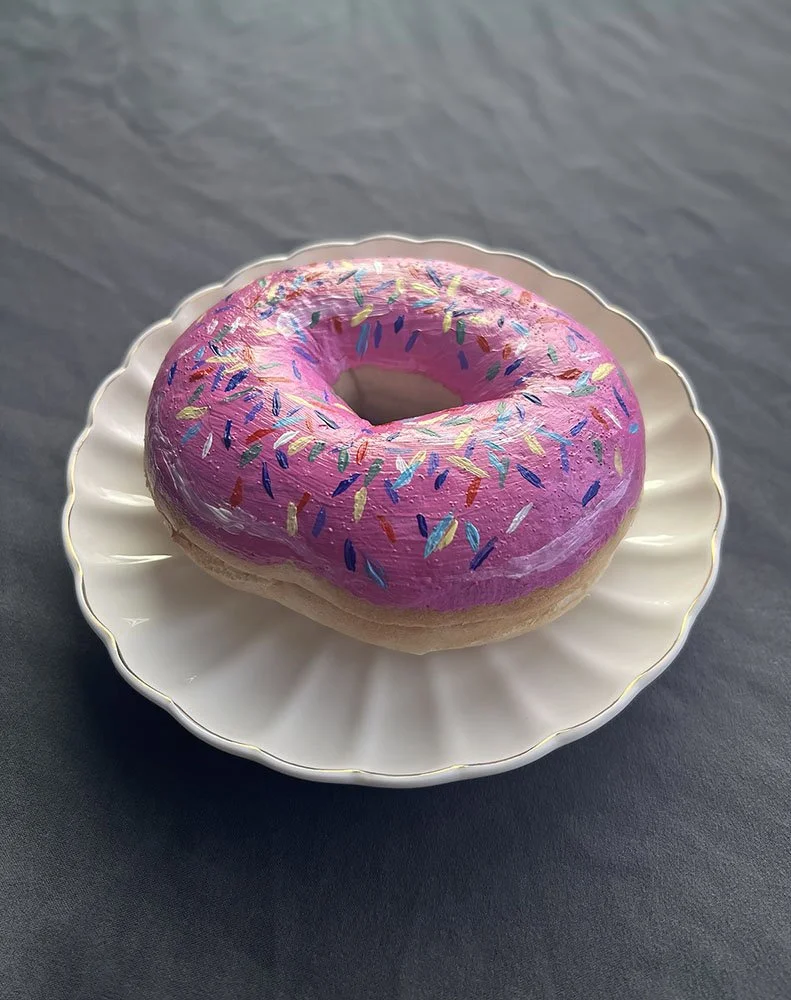 Emma Rarick. "Disguised," Jan 2026, acrylic on bagel,  5x5".