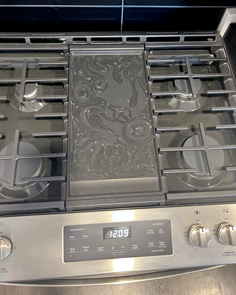 Emma Rarick. “New Stove," dust on new stove, June 2026.