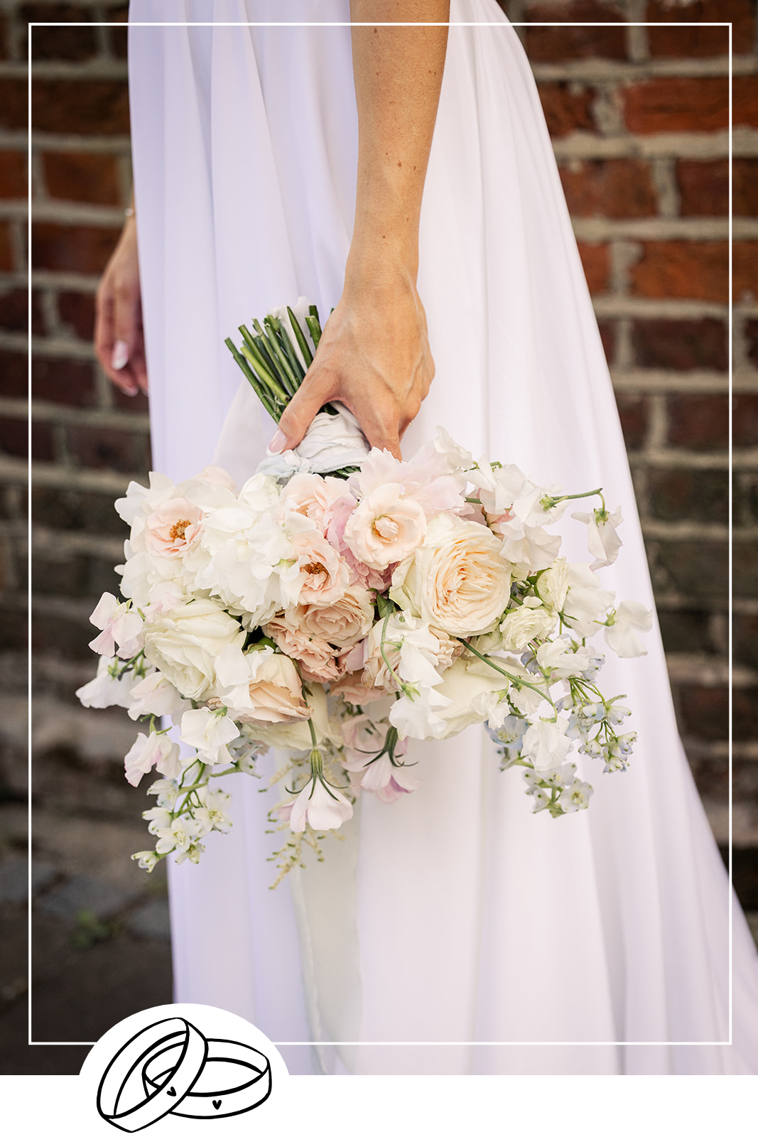 A wedding bouquet of pink, white and light blue flowers with a silk trailing ribbon