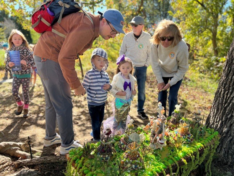 A family surrounds a fairy village.
