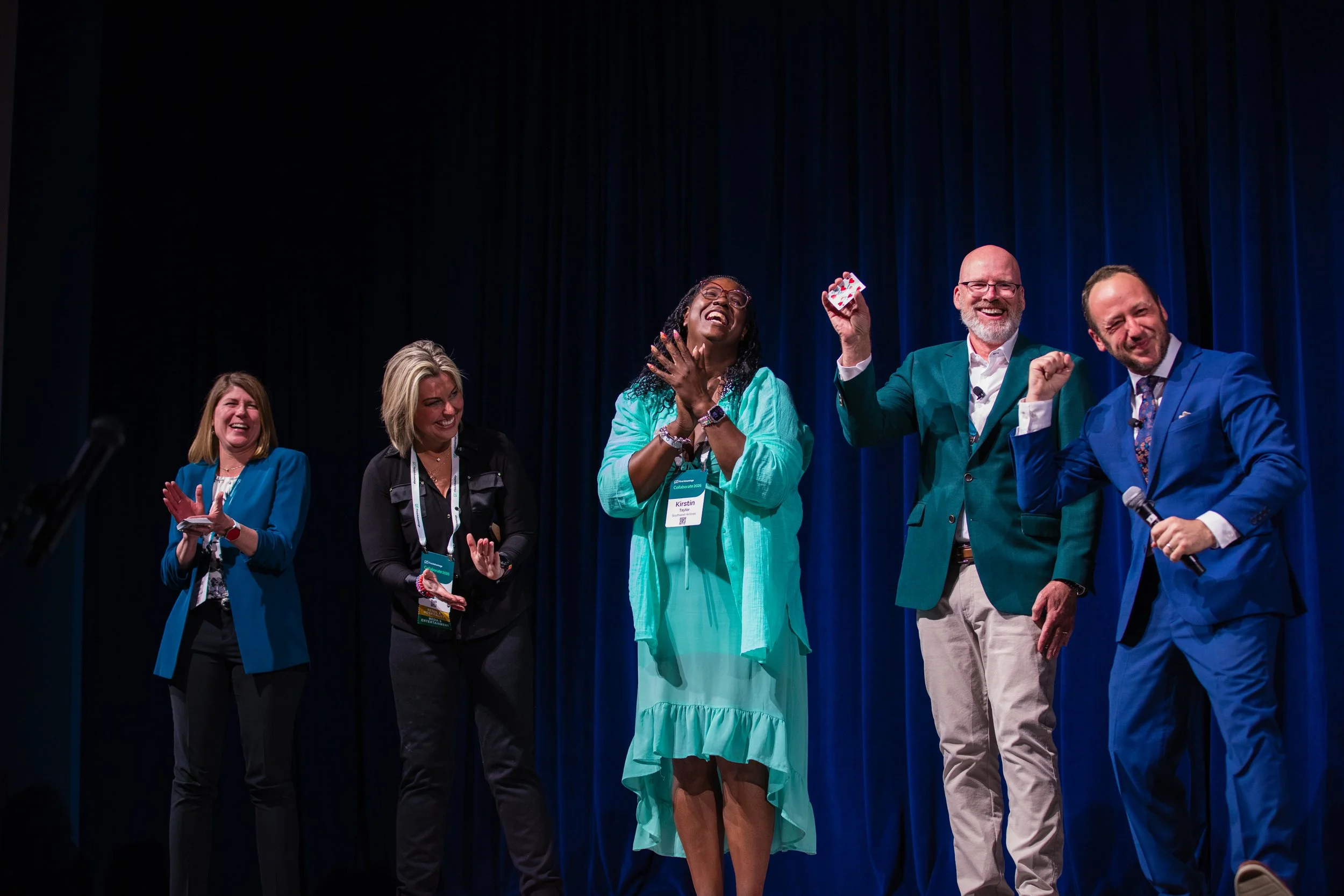 Kostya Kimlat performing his personality card trick on stage with four volunteers at First Advantage's Collaborate conference.