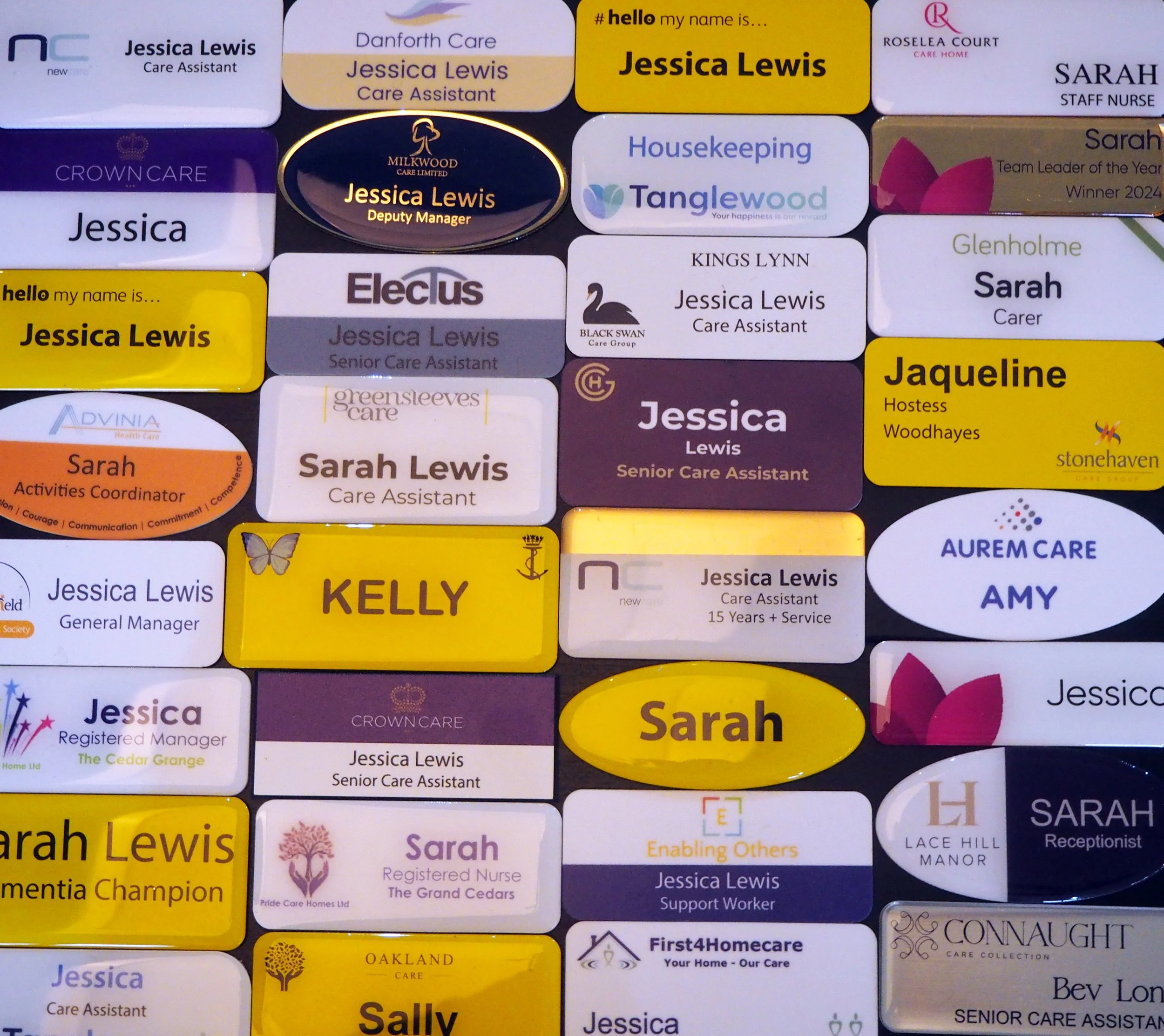 Collection of name badges for staff members at a care home, featuring names, titles, and care home logos. Prominent names include Jessica Lewis, Sarah Lewis, Kelly, and Sarah.