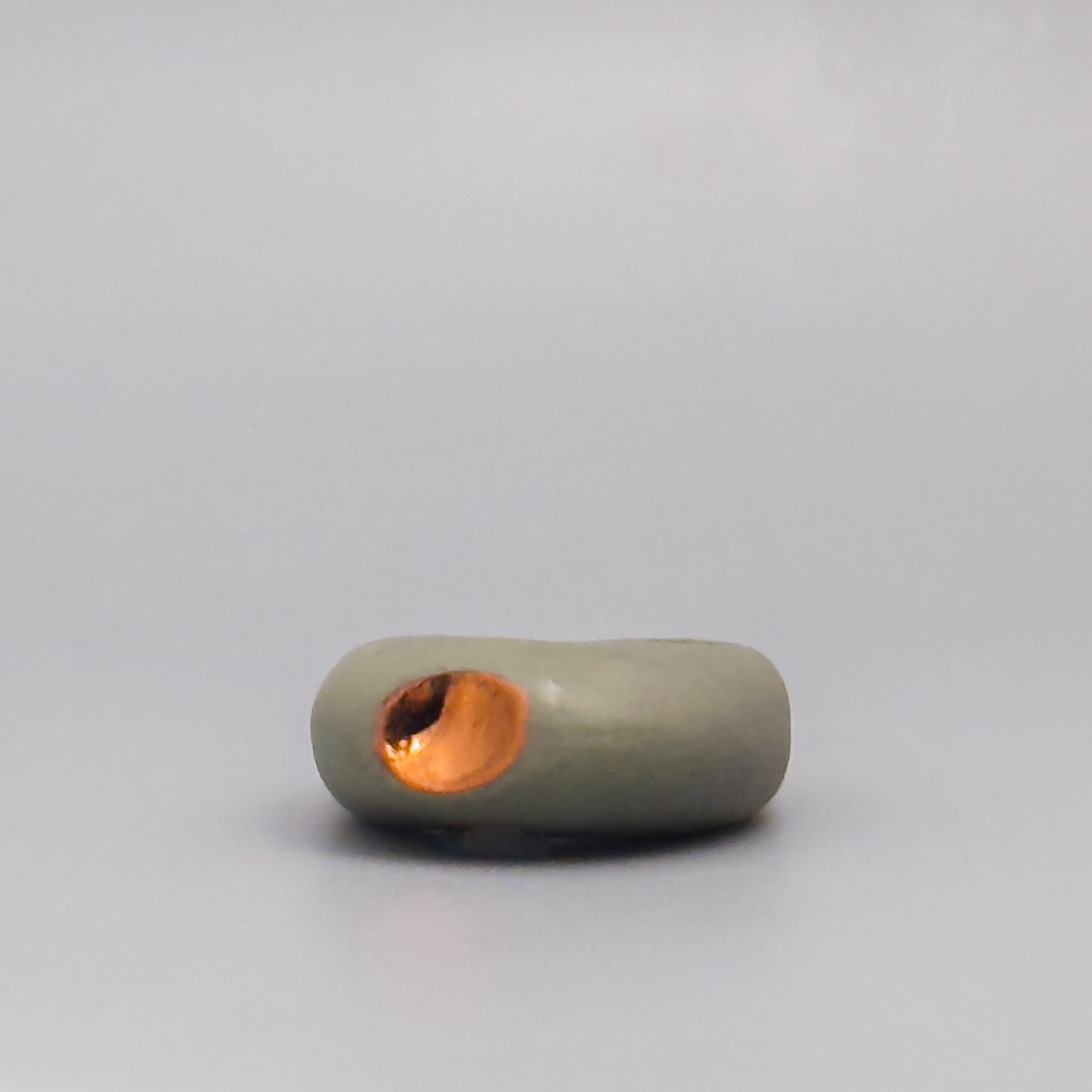 Copper luster porcelain ring, unglazed matte olive surface with fired accent