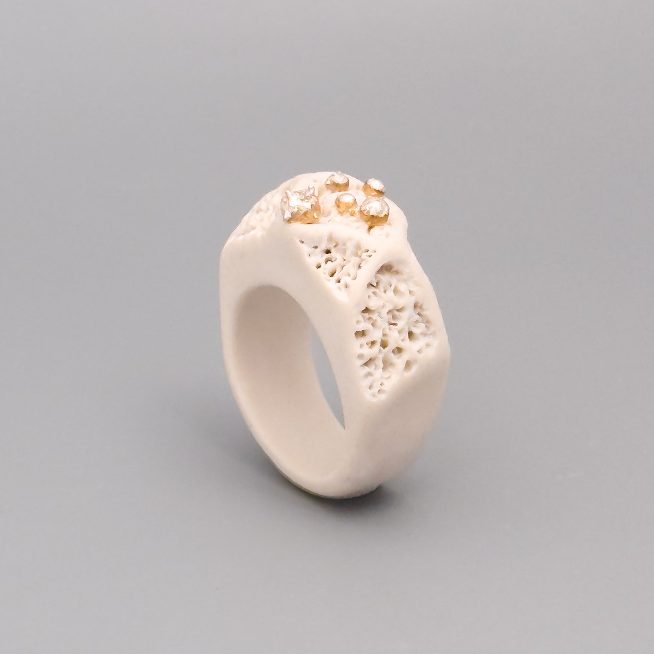 Profile view of coral-inspired porcelain ring, highlighting hand-carved texture and elevated silver grains