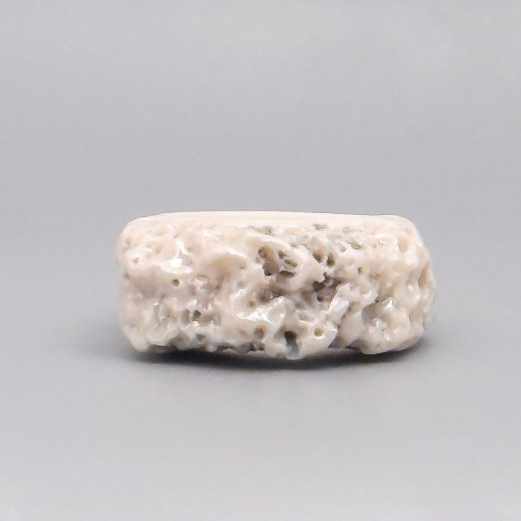 Close-up of white porcelain coral ring handmade by Brooklyn ceramic artist – iridescent luster and sculptural surface