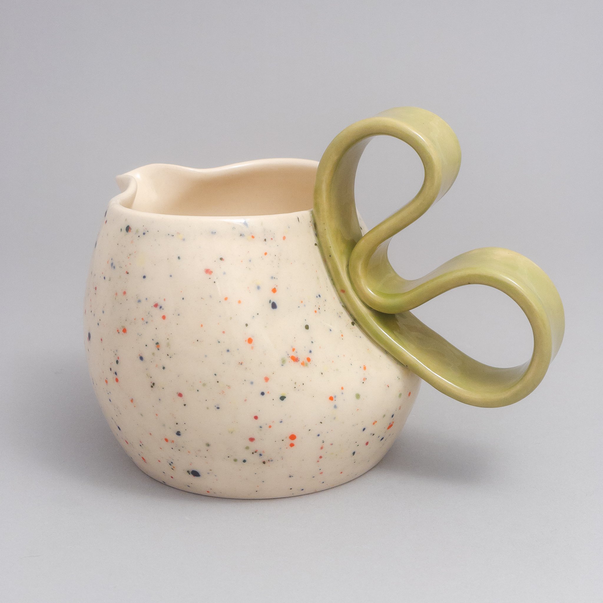 Angled view of the Confetti series pitcher with a blue ribbon handle, hand-thrown and altered in Brooklyn