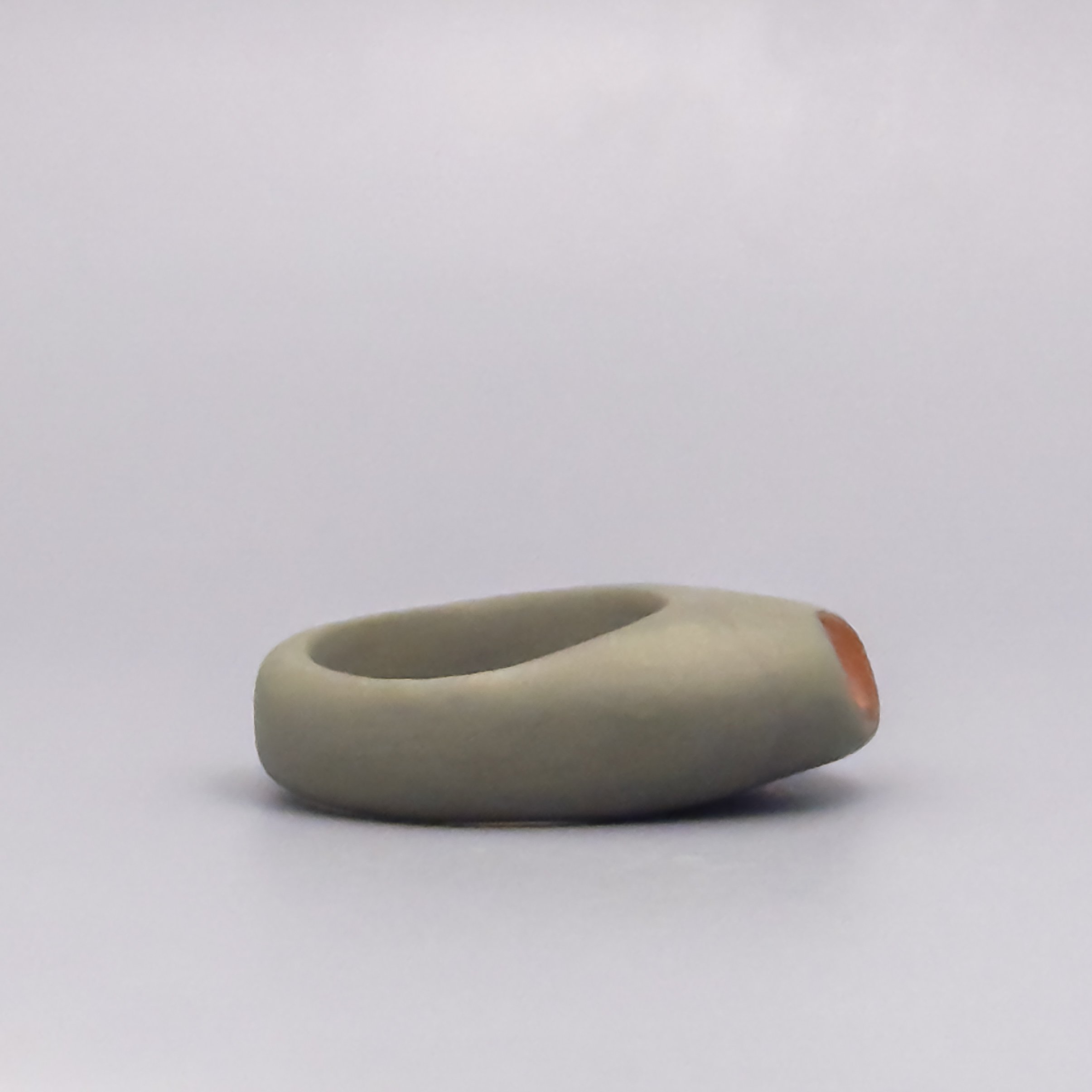 Modern olive porcelain ring with warm copper luster hollow, side angle