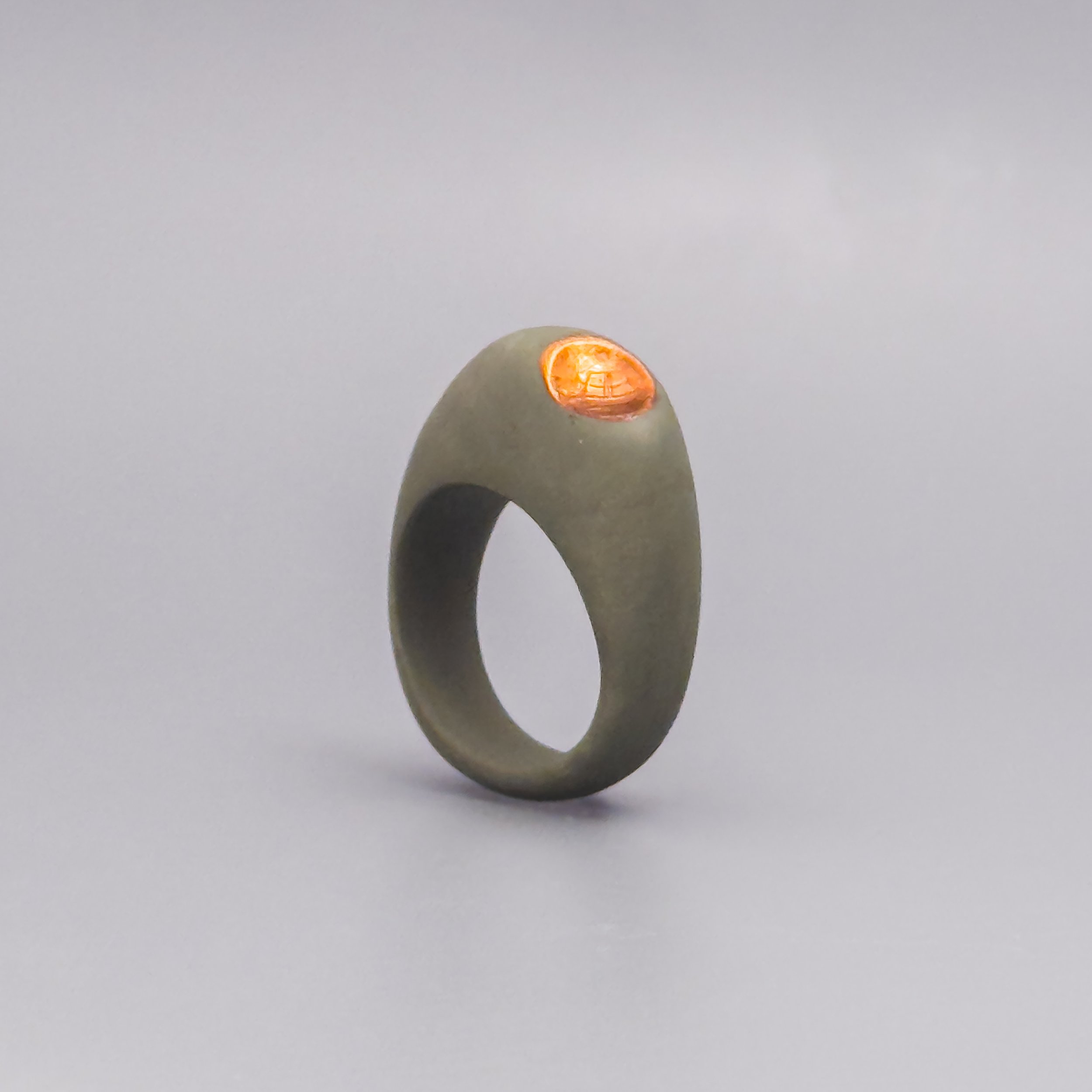 Handmade olive porcelain ring with copper luster detail, angled view