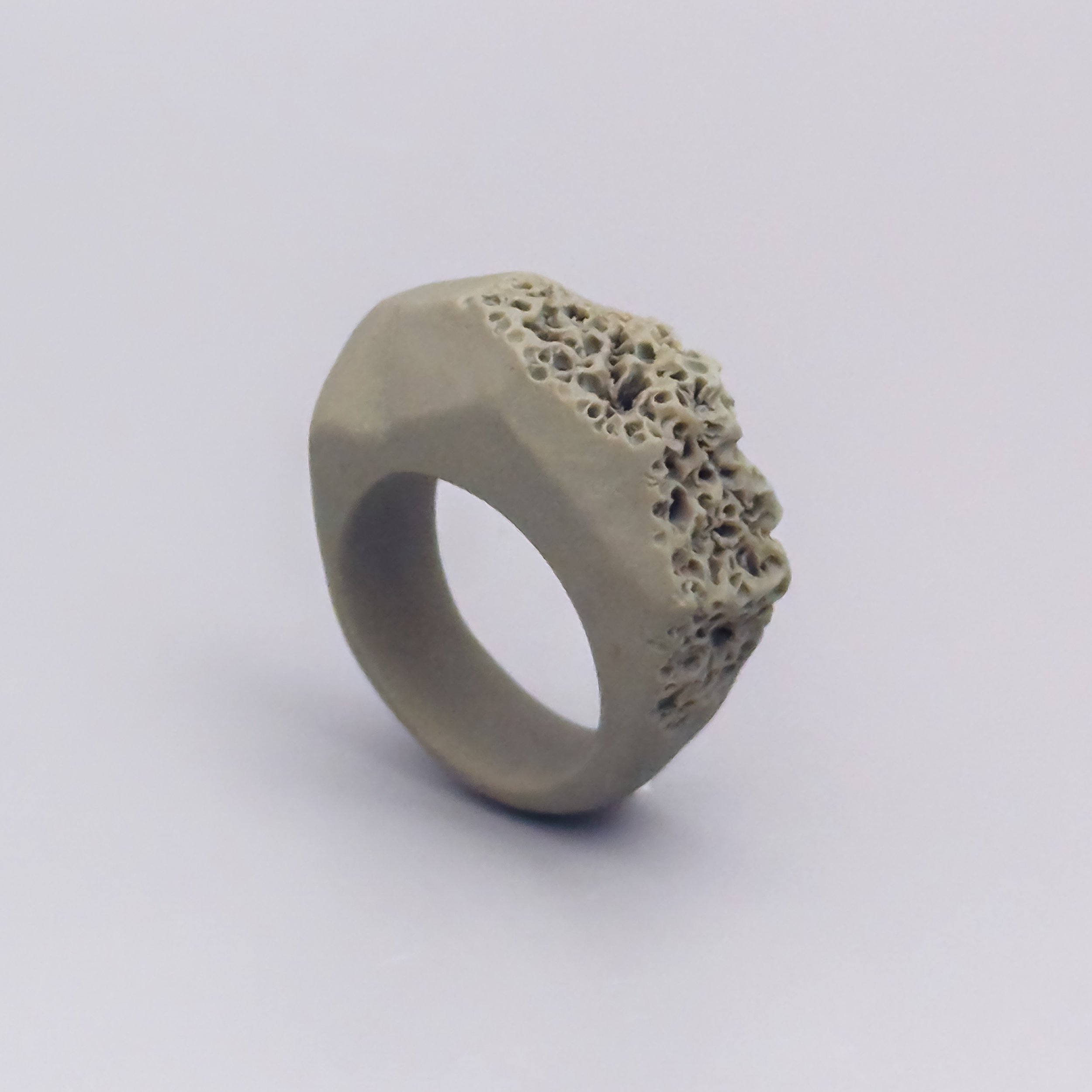 Faceted porcelain ring with pale matte surface and porous coral structure handmade in Brooklyn