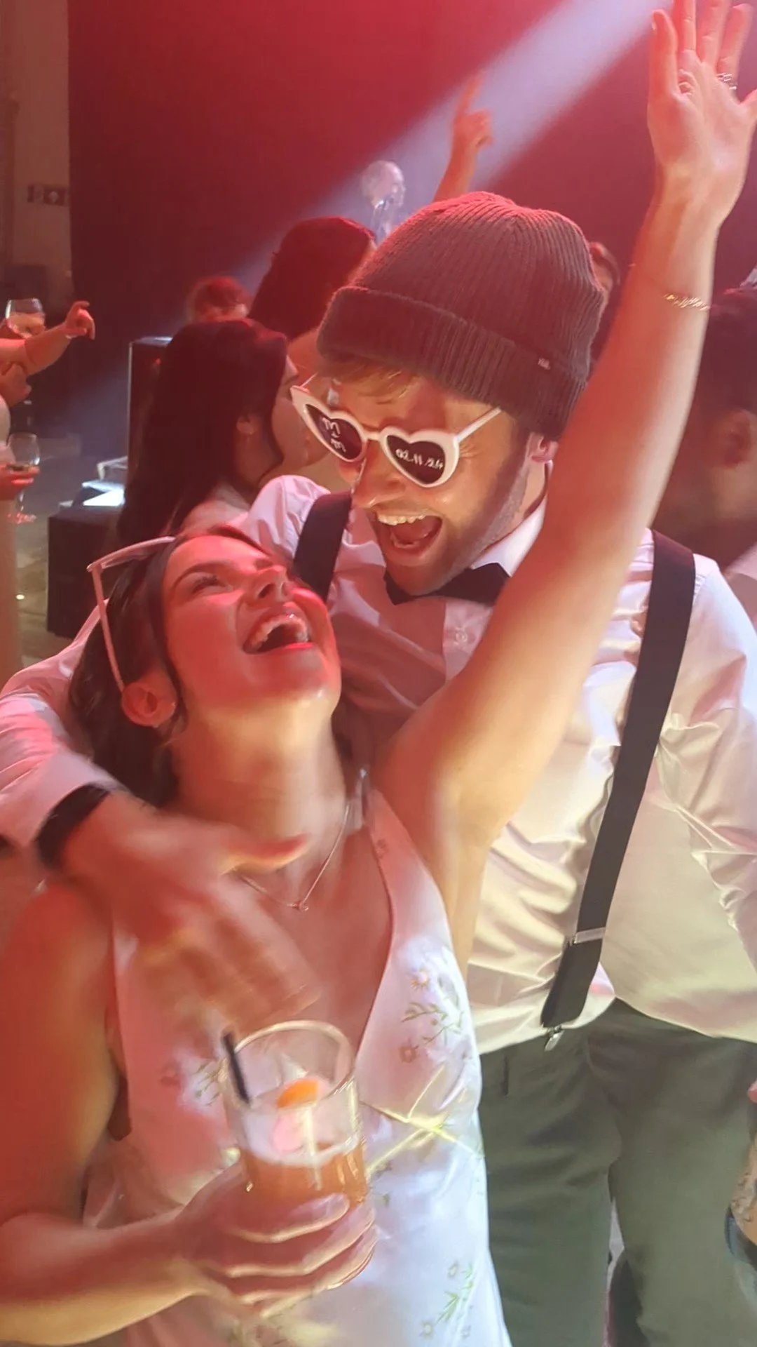 A youn bride and groom dance and laugh at their wedding party.