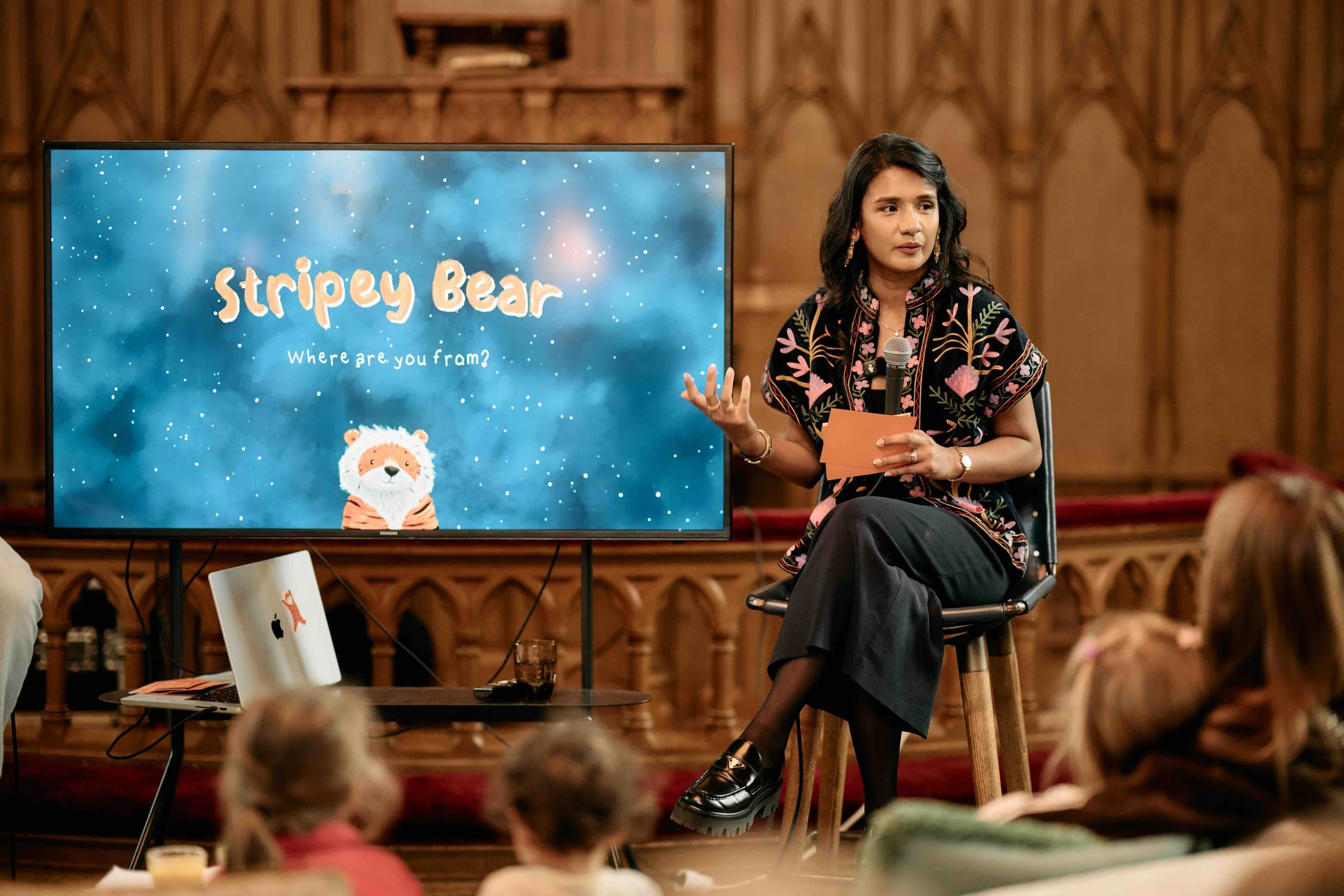 Author speaking about Stripey Bear during the book launch at Soho in Stockholm, with the Stripey Bear story displayed on screen.