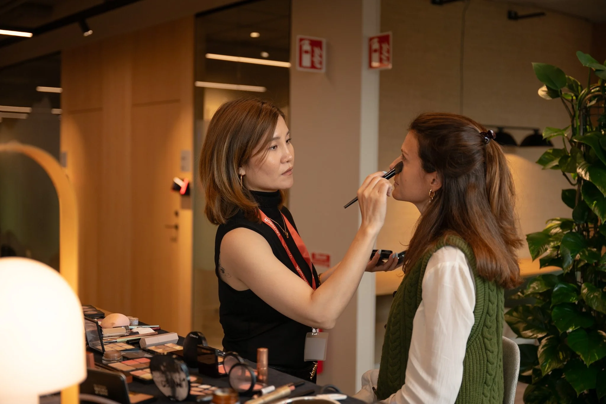Makeup artist preparing a Microsoft Sweden employee for a corporate portrait session