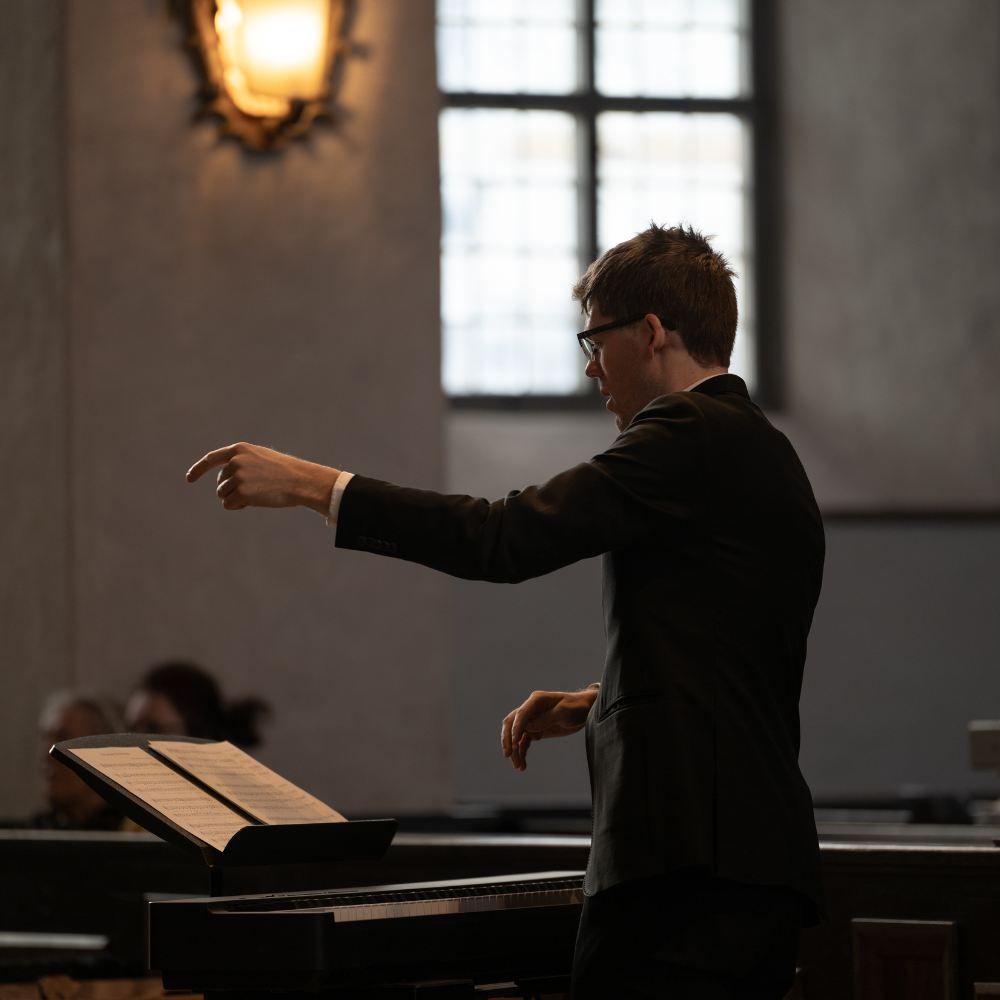 Choirmaster conducting the choir during a Sunday service at Högalidskyrkan