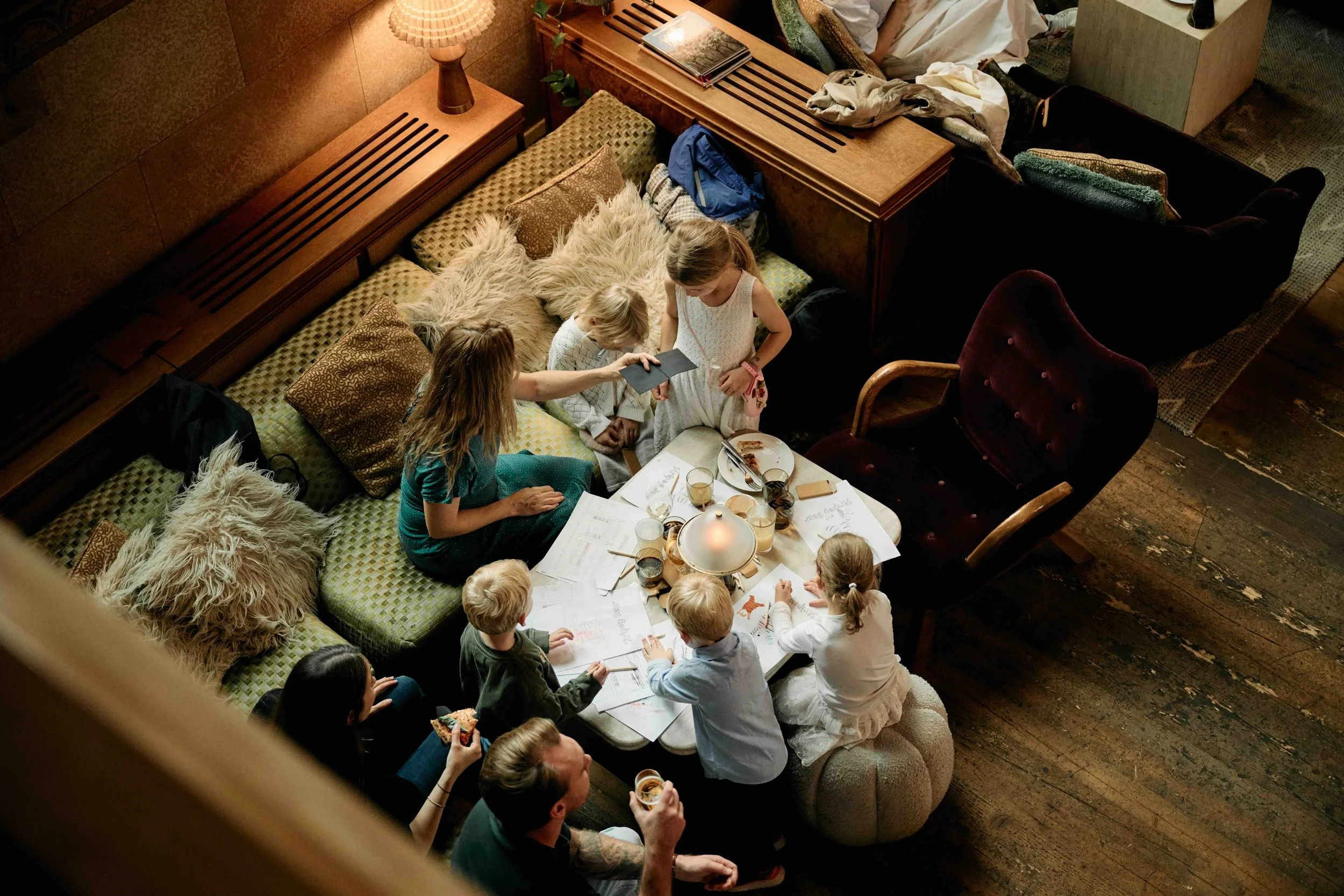Families gather around a table to explore books and creative materials during the Stripey Bear — Where Are You From? launch event at Soho House Stockholm.