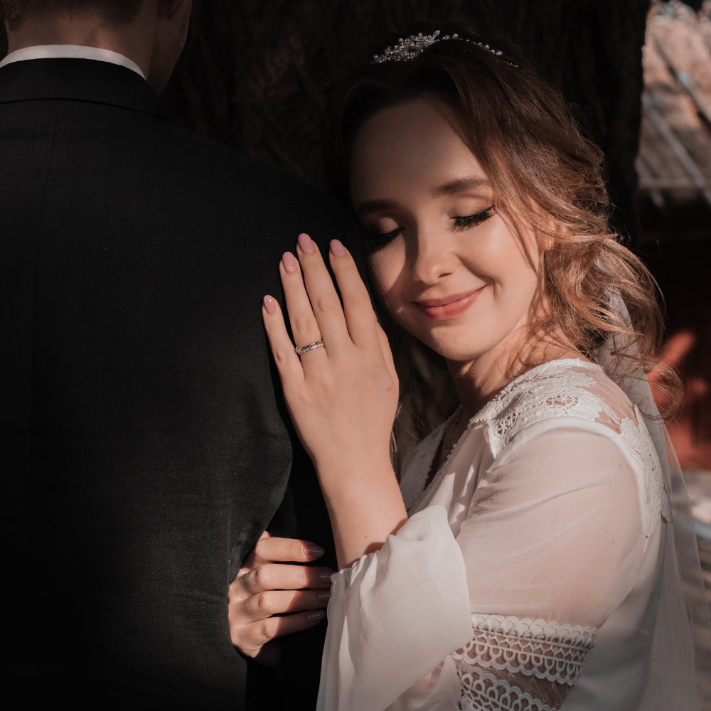 Bride leaning against the groom during an outdoor wedding portrait session