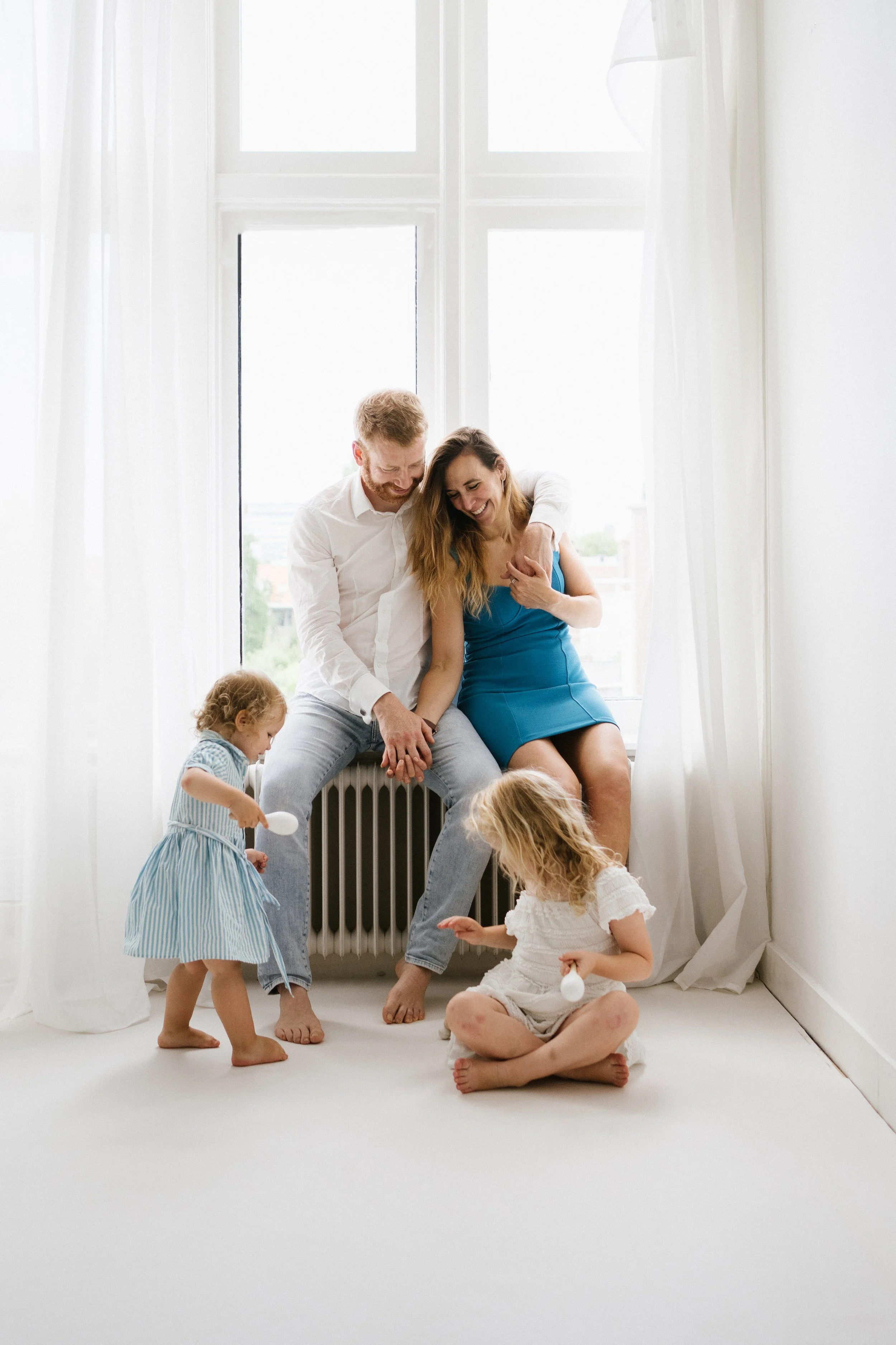 family of four sharinga plauful moment with two young children during a relaxed lifestyle family photoshoot