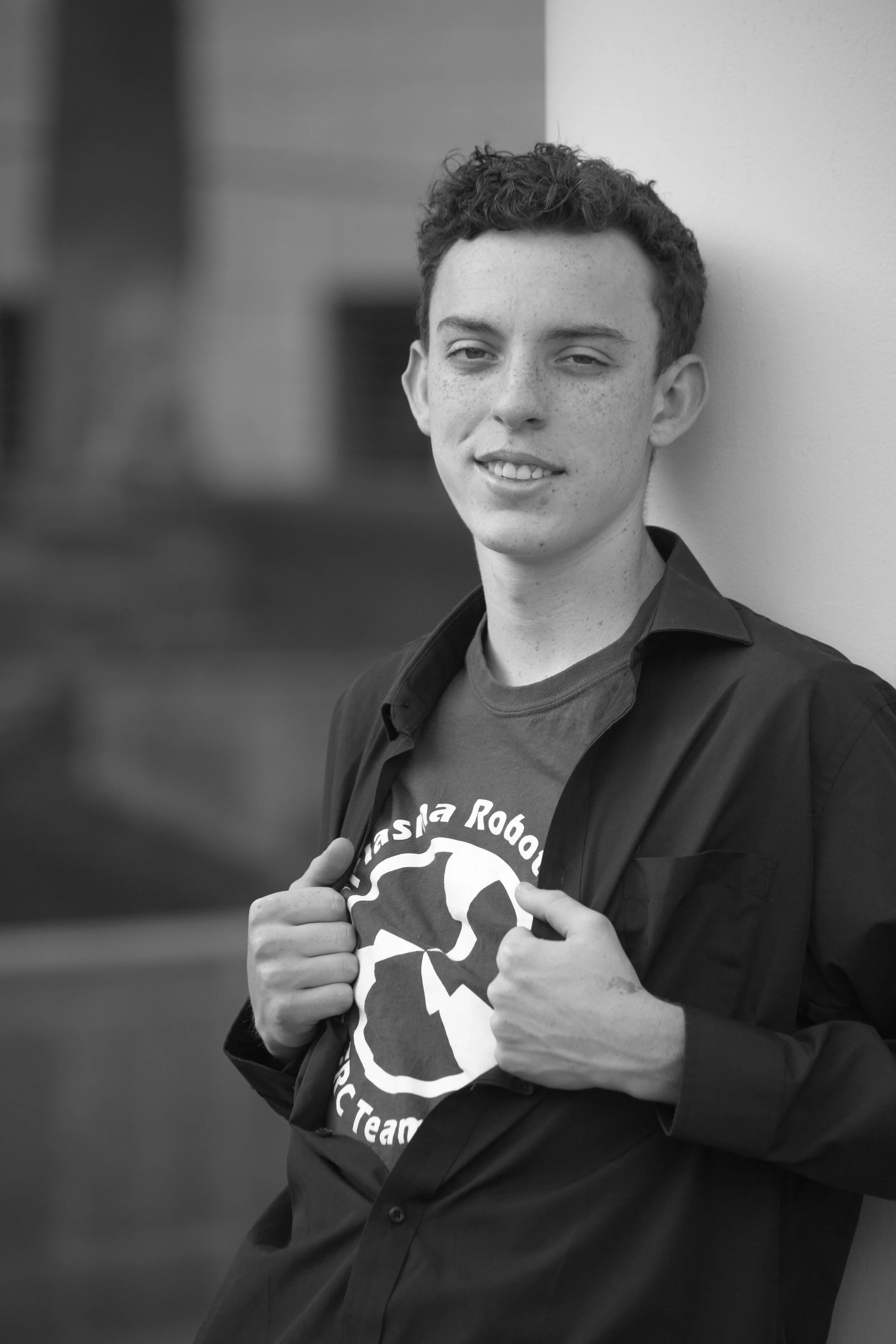 Male high school senior opening his shirt to show a robotics team logo during a Phoenix photo session