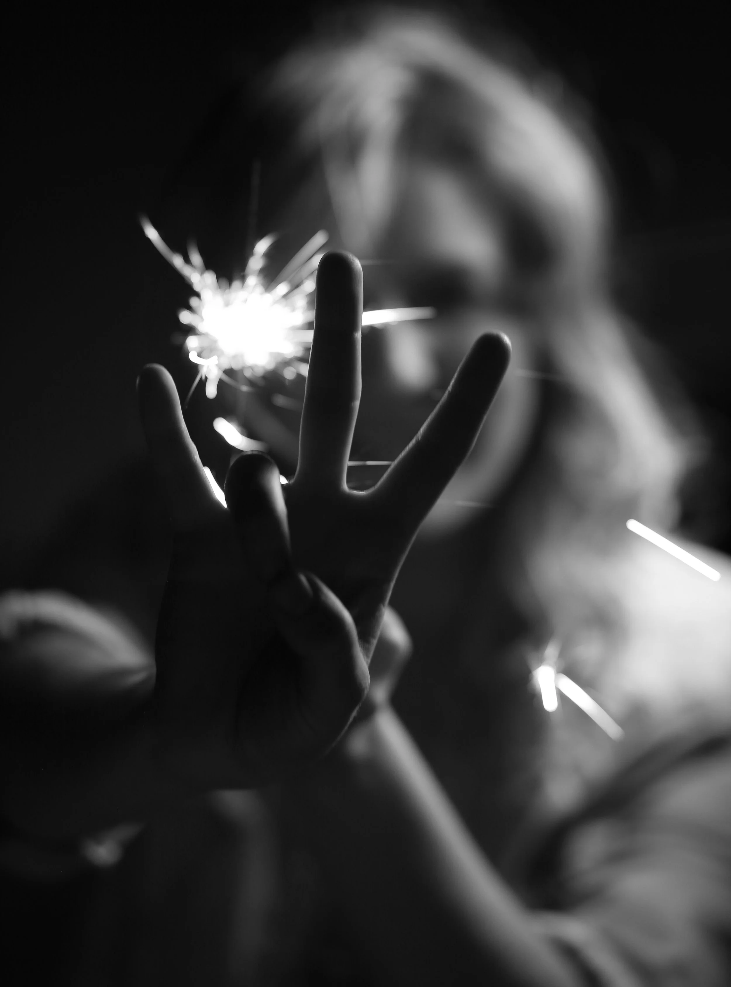 Arizona State University graduate portrait with sparkler and hand focus in black and white