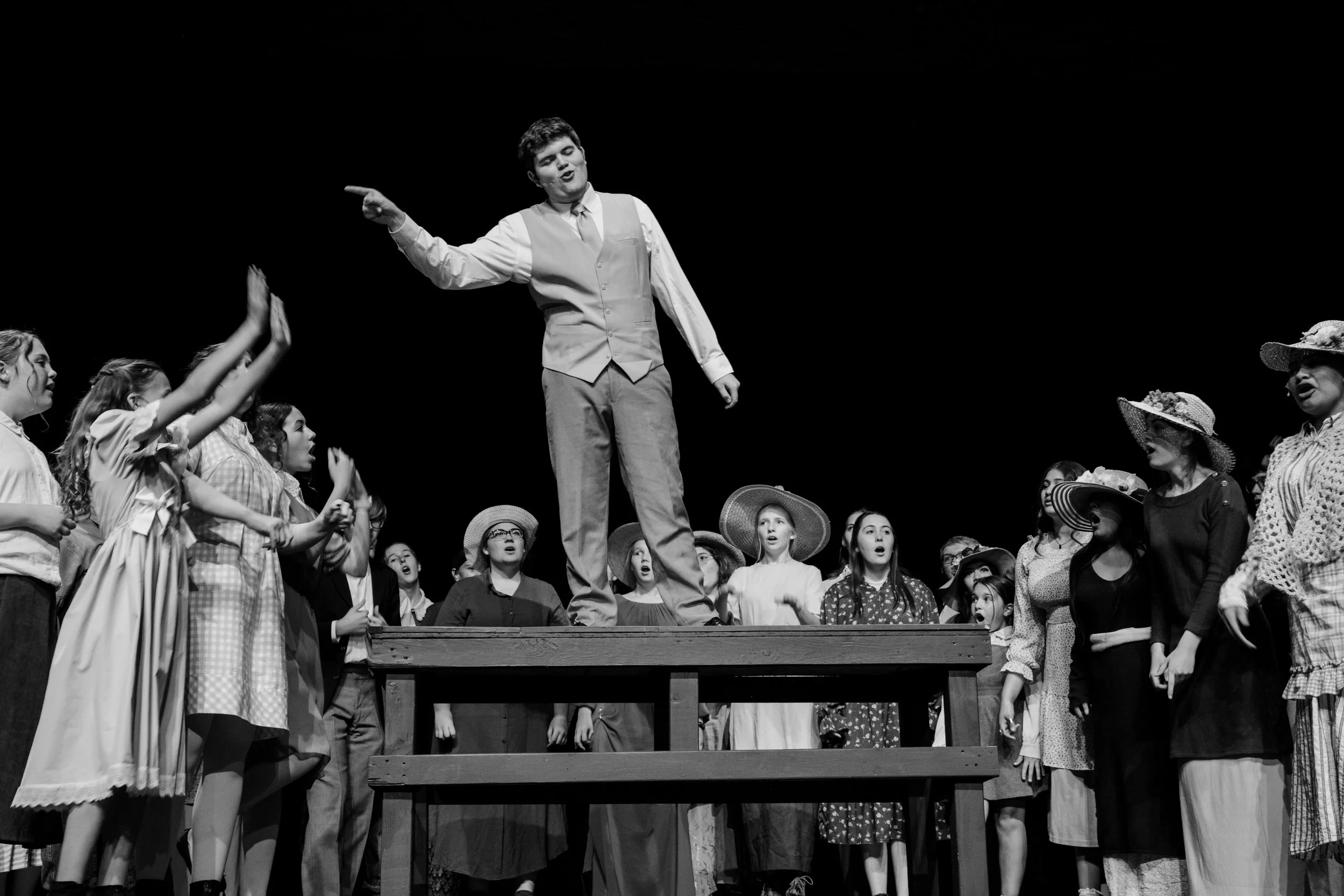 Black and white image of Professor Harold Hill from Music Man standing on a table