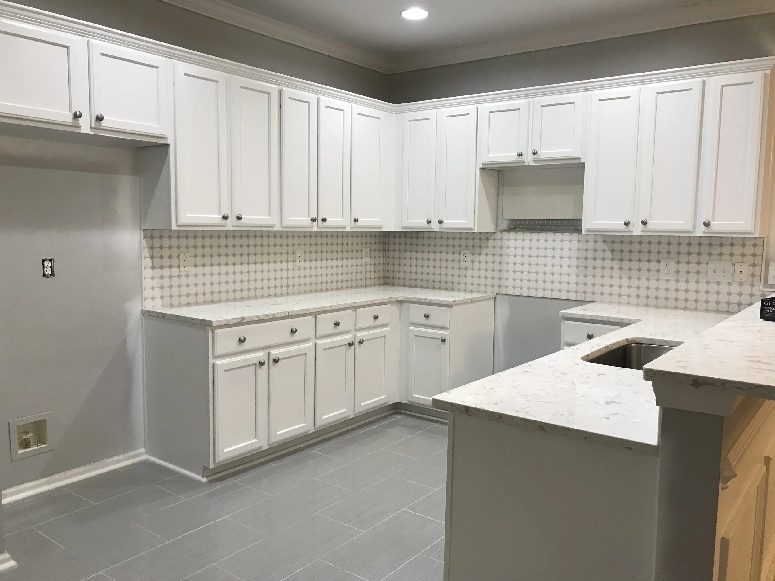 after photo of white kitchen cabinet and counter backsplash