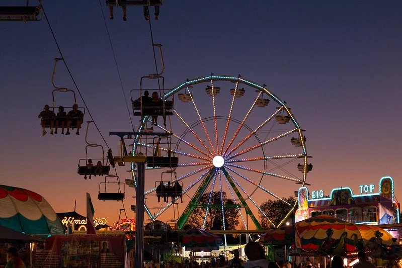 People riding a Ferris wheel at an amusement park during twilight.