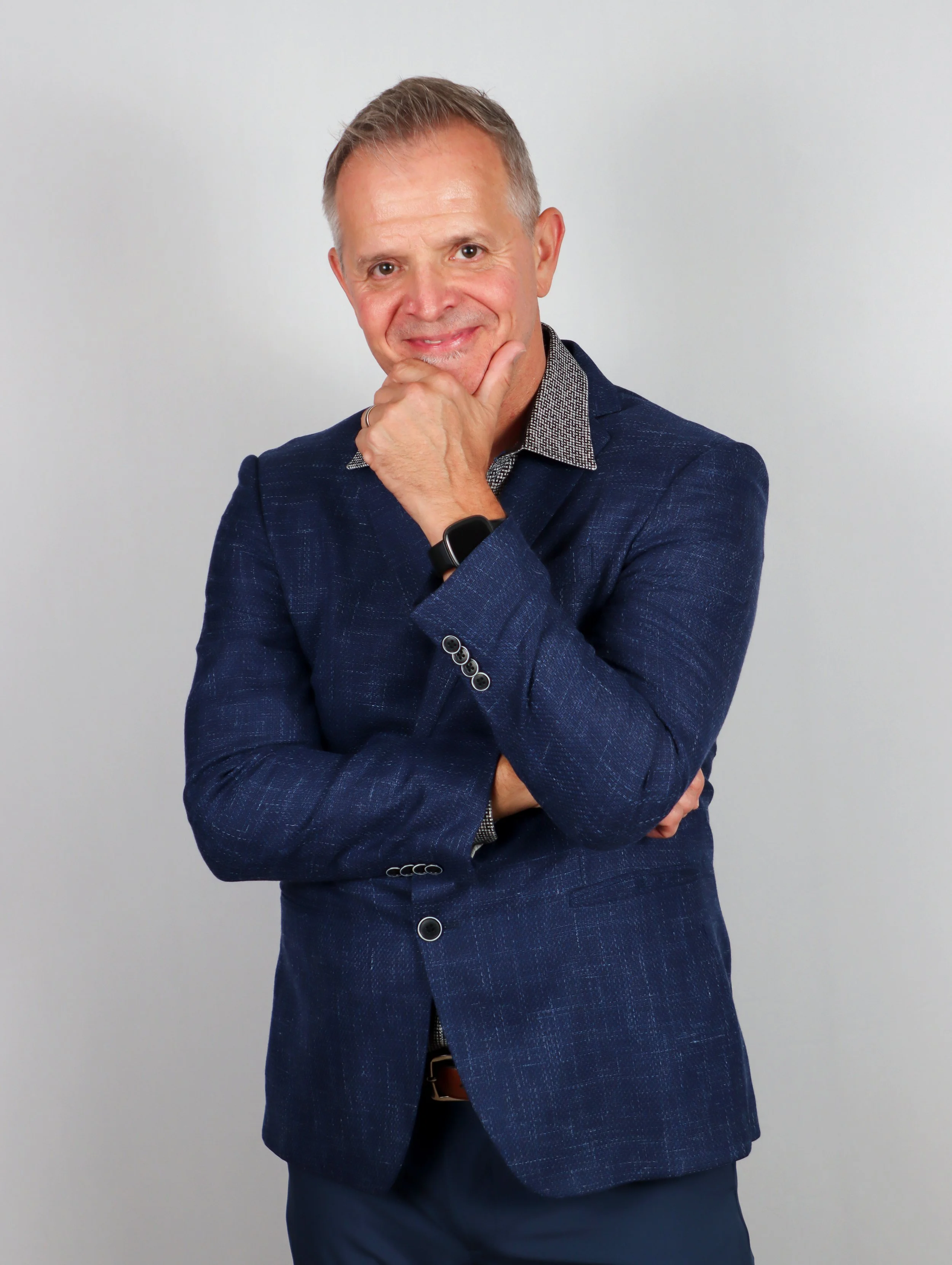 Matt Booth standing with arms crossed and hand on chin