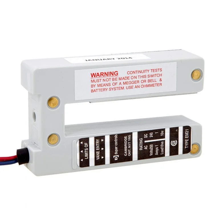 A white proximity switch with a warning label and a brown and white label with technical specifications.