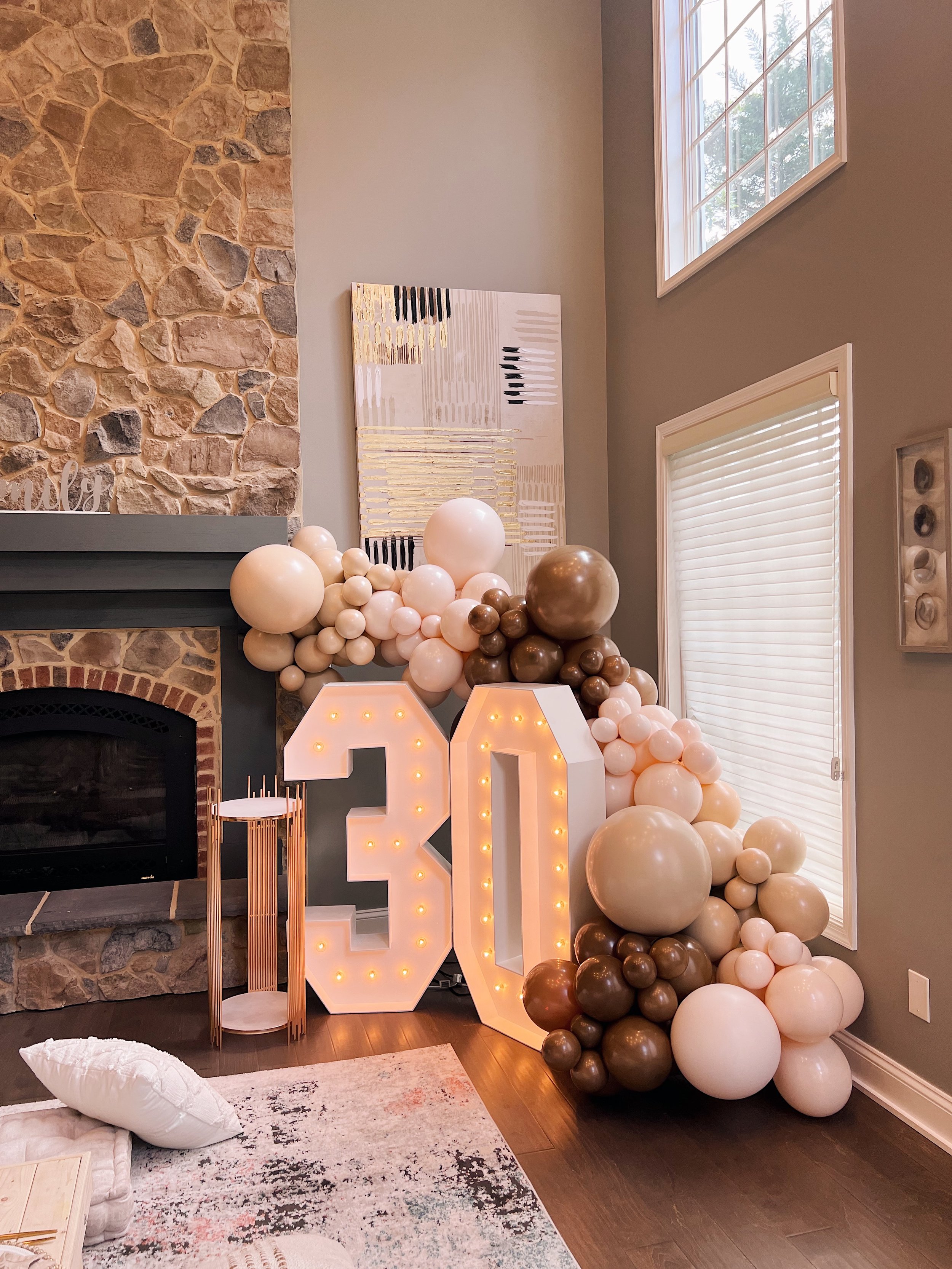 Marquee letters on a sign propped up on a pillow in front of an indoor picnic designed by Picnics By Peace