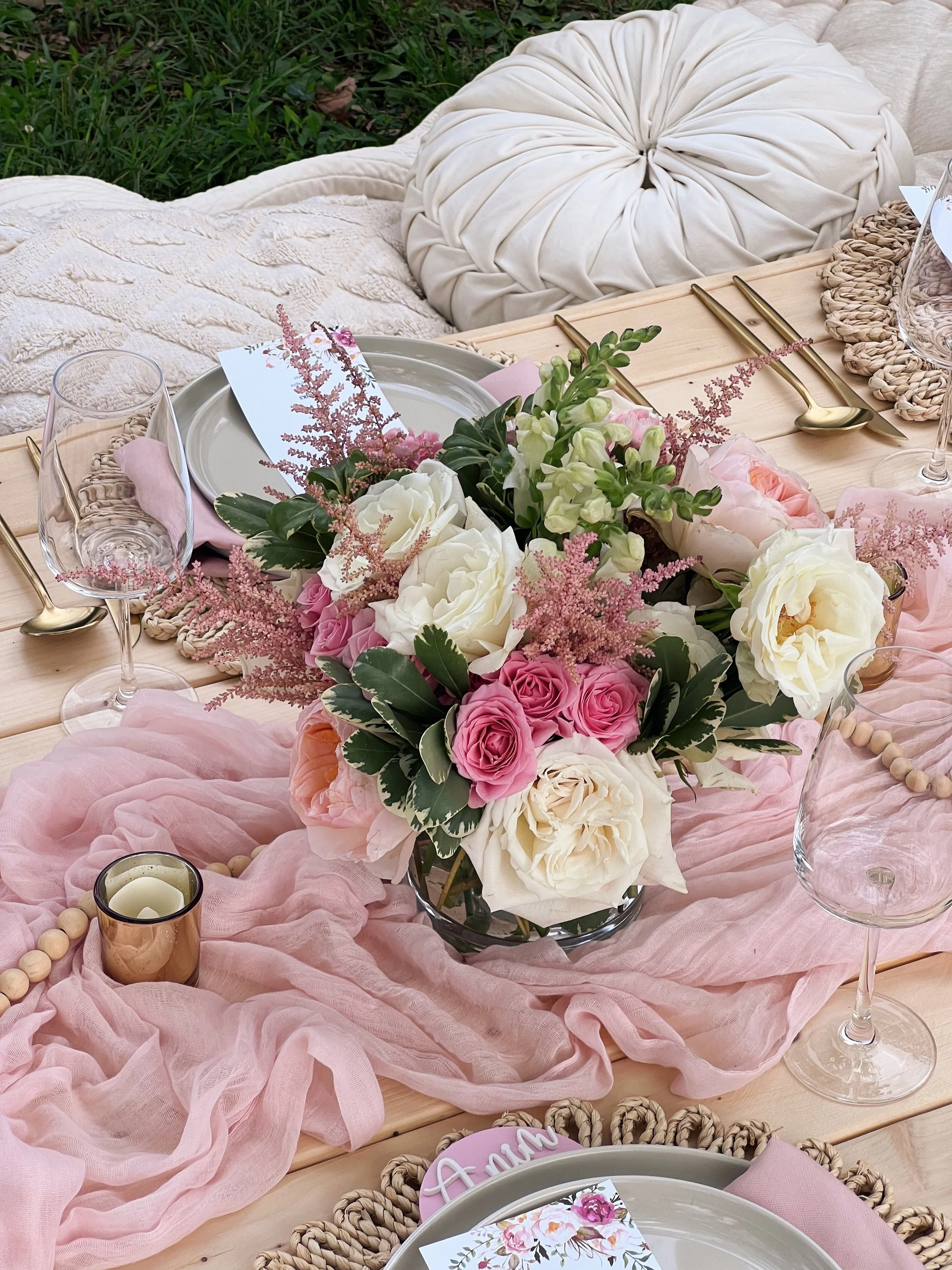 Fresh floral arrangement on small outdoor picnic table available from Picnics By Peace